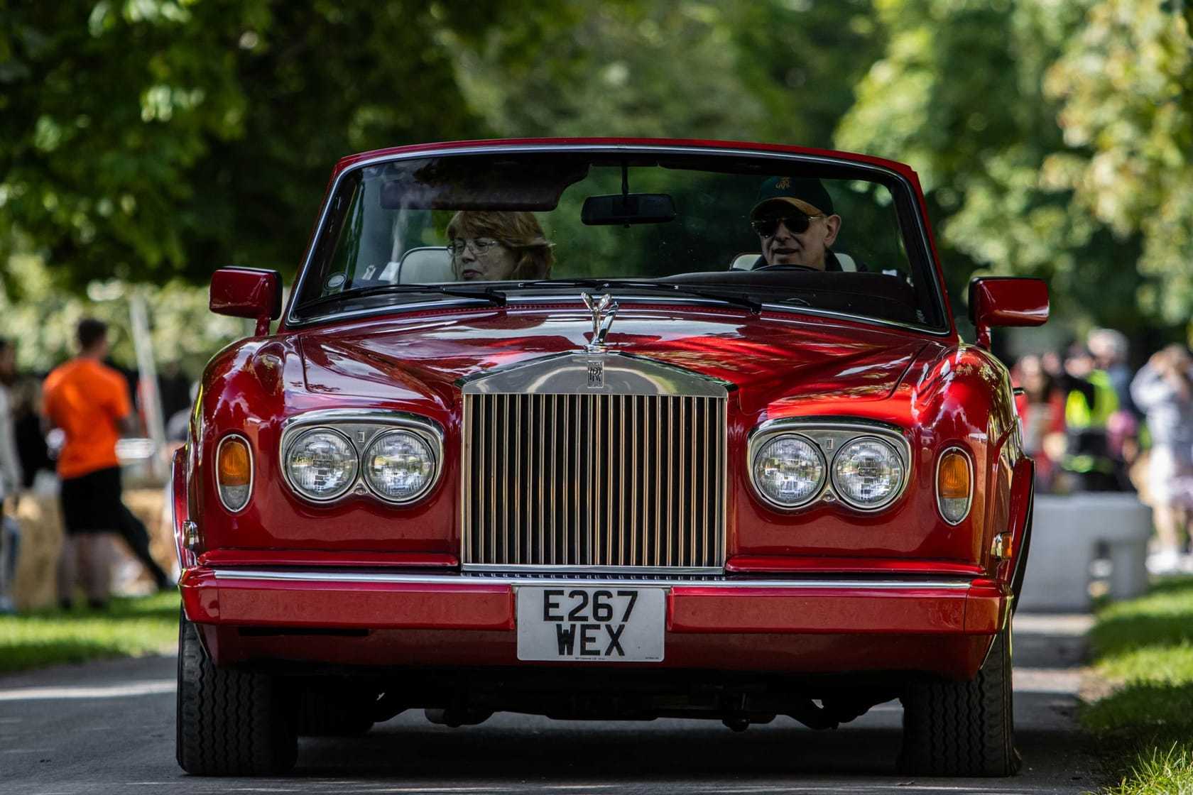 A red Rolls-Royce Corniche convertible with UK registration E267 WEX photographed head-on at an event