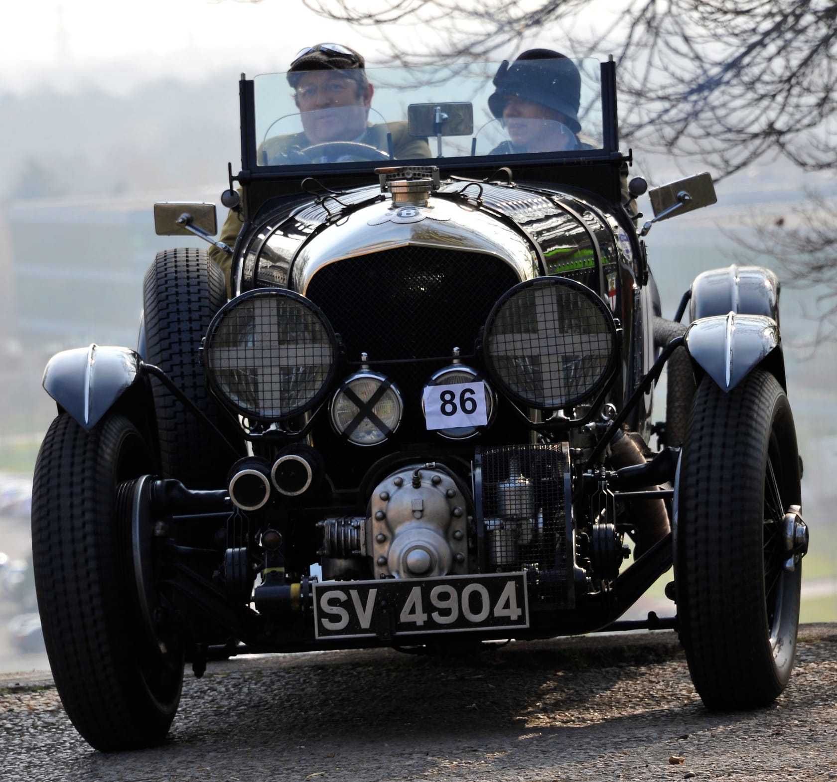 A supercharged Bentley 4½ Litre Blower with crew at the top of the Brooklands test hill
