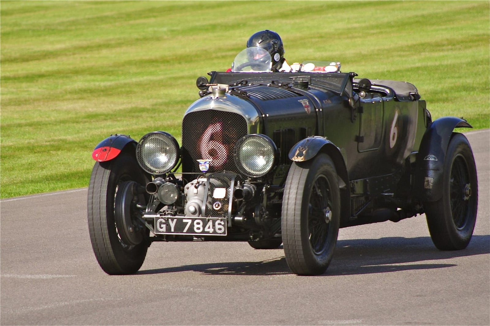 A green 1930 supercharged Bentley 4½ Litre Blower with racing number 6 on a circuit