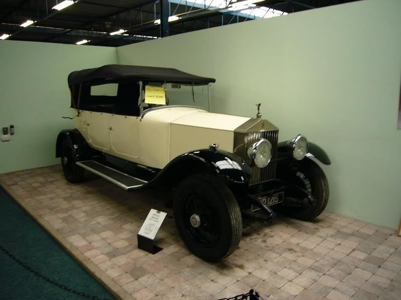 A cream and black 1930 Rolls-Royce 20/25 tourer displayed in a museum