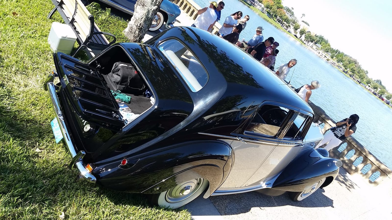 A black and silver two-tone 1952 Bentley Mk VI at a waterside classic car show