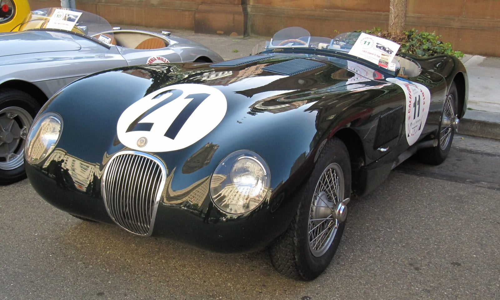 A dark green 1953 Jaguar C-Type with racing number 21, front three-quarter view