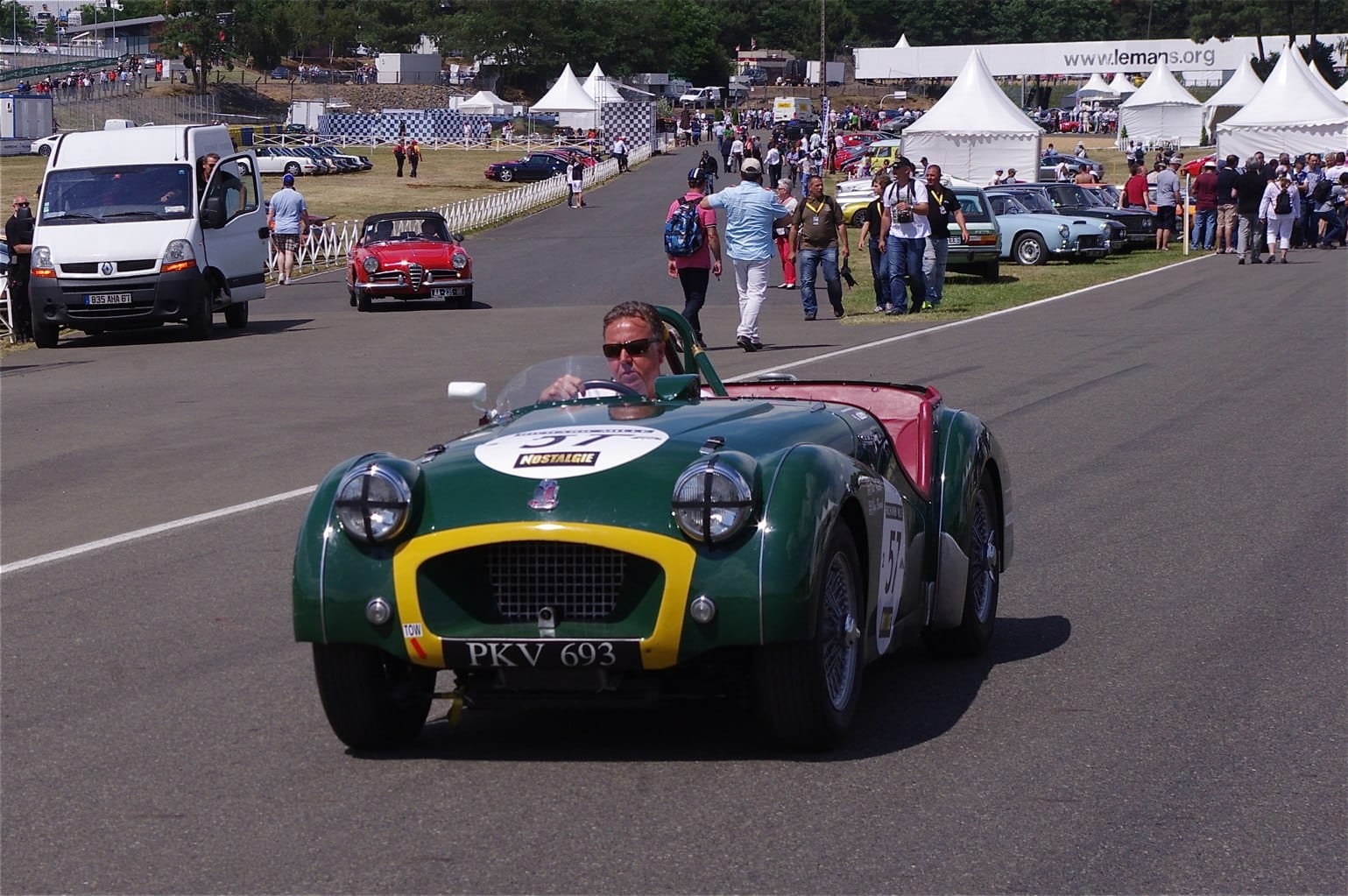 A green Triumph TR2 racing car on a circuit