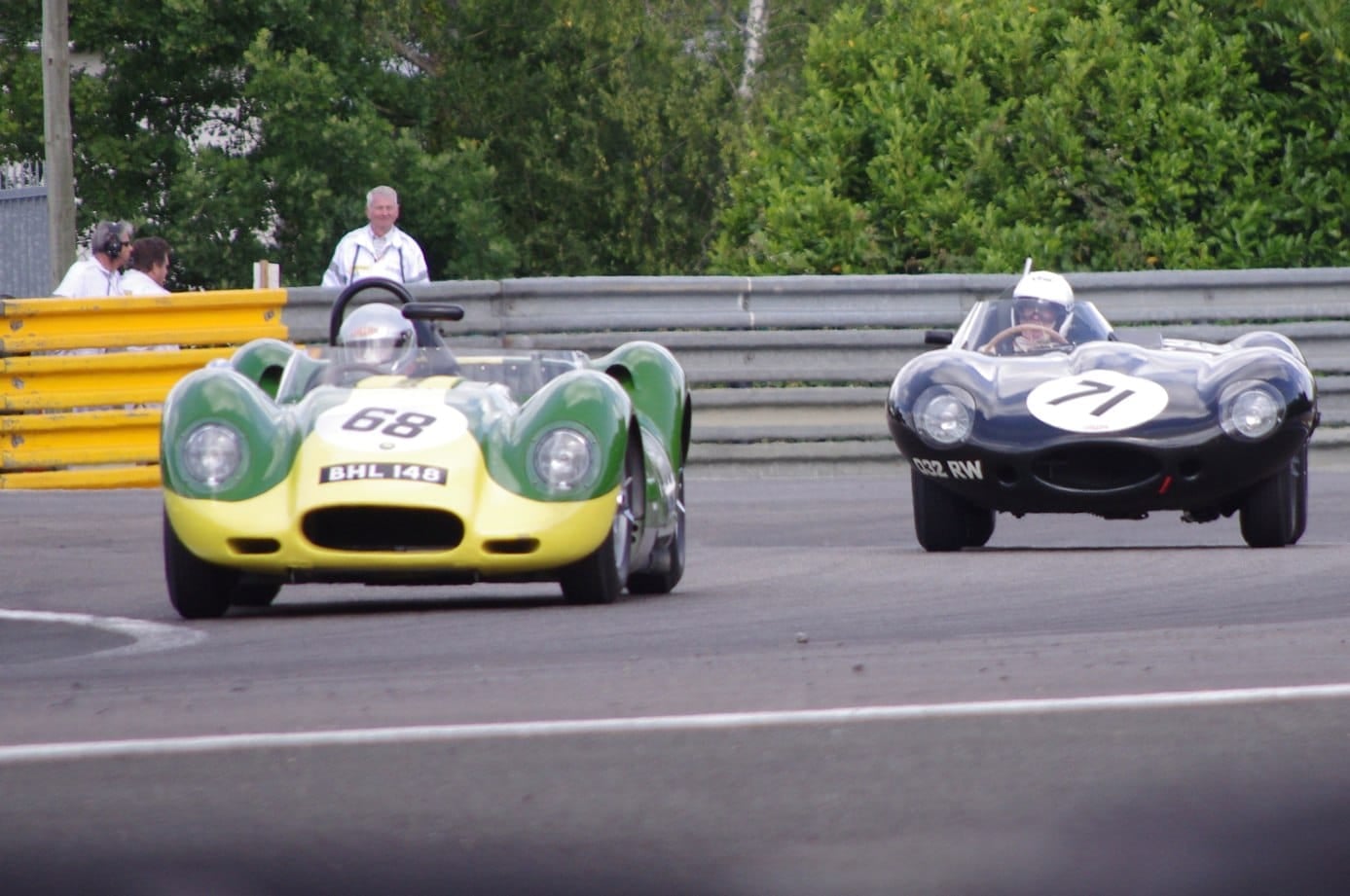 A Lister Knobbly and a Jaguar D-Type racing wheel to wheel on a circuit