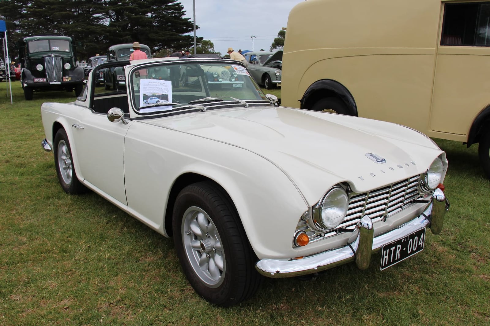 A white Triumph TR4 roadster at a show