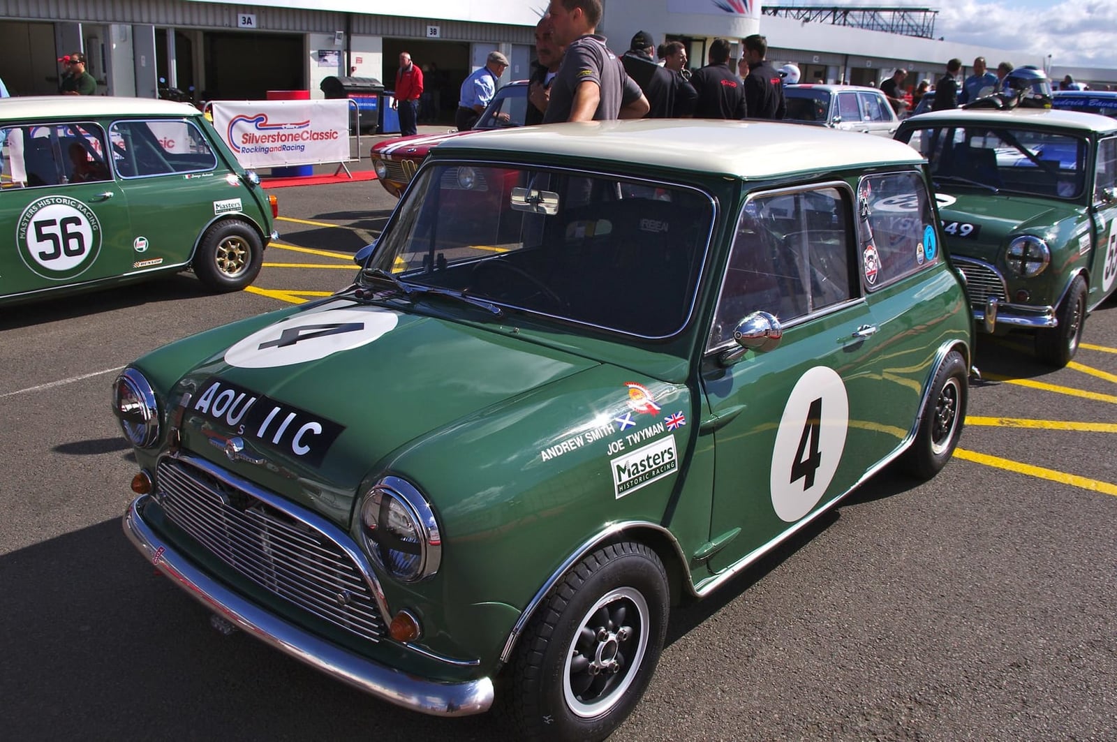 A green Mini Cooper race car at a historic meeting