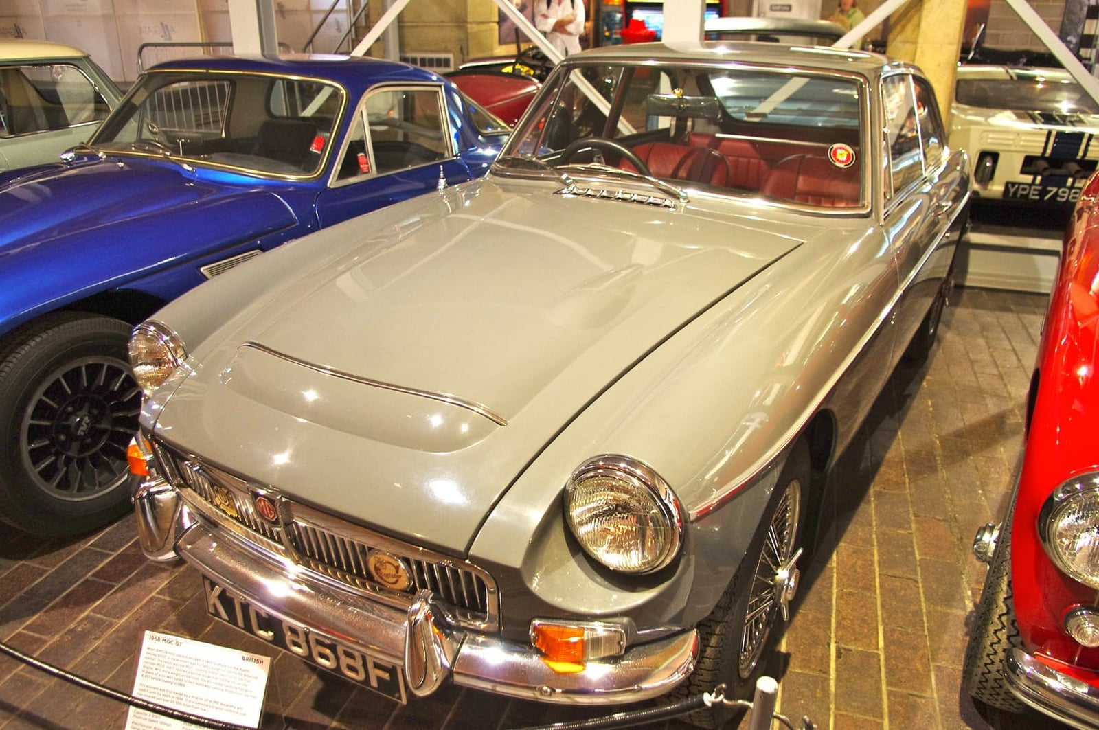 A tan MG MGC GT, front three-quarter view