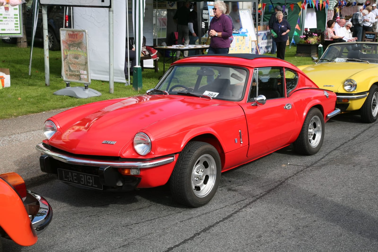 An orange Triumph GT6, front three-quarter view at a show