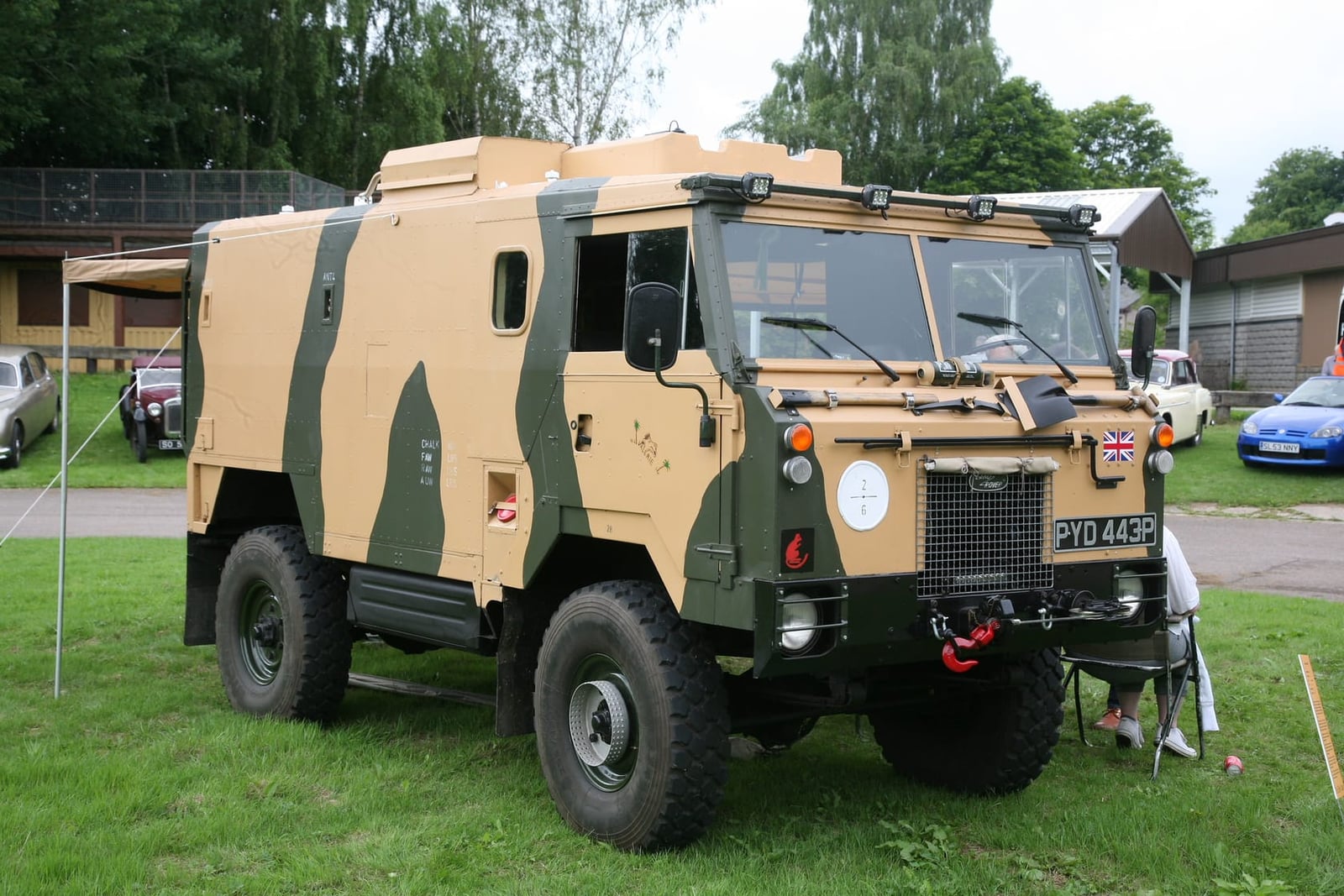 A camouflaged 1975 Land Rover 101 Forward Control one-tonne truck, front three-quarter view
