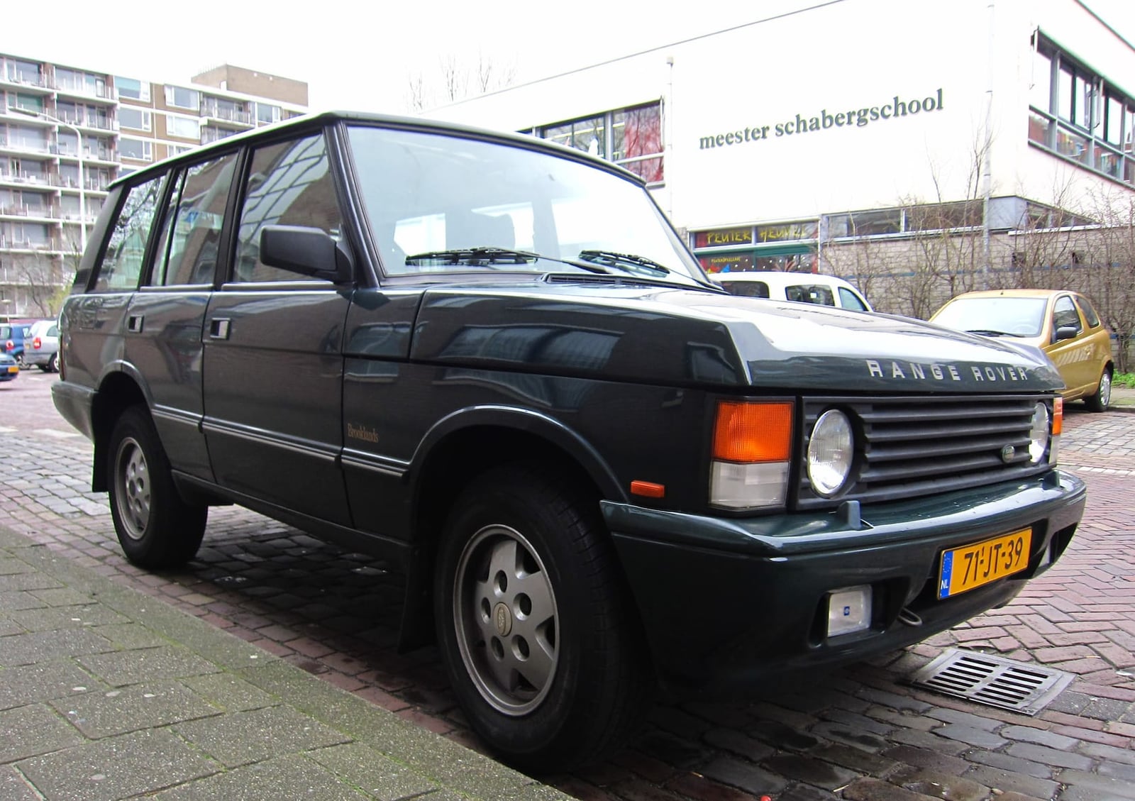 A dark green four-door Range Rover Classic in mid-1990s Brooklands trim, parked kerbside