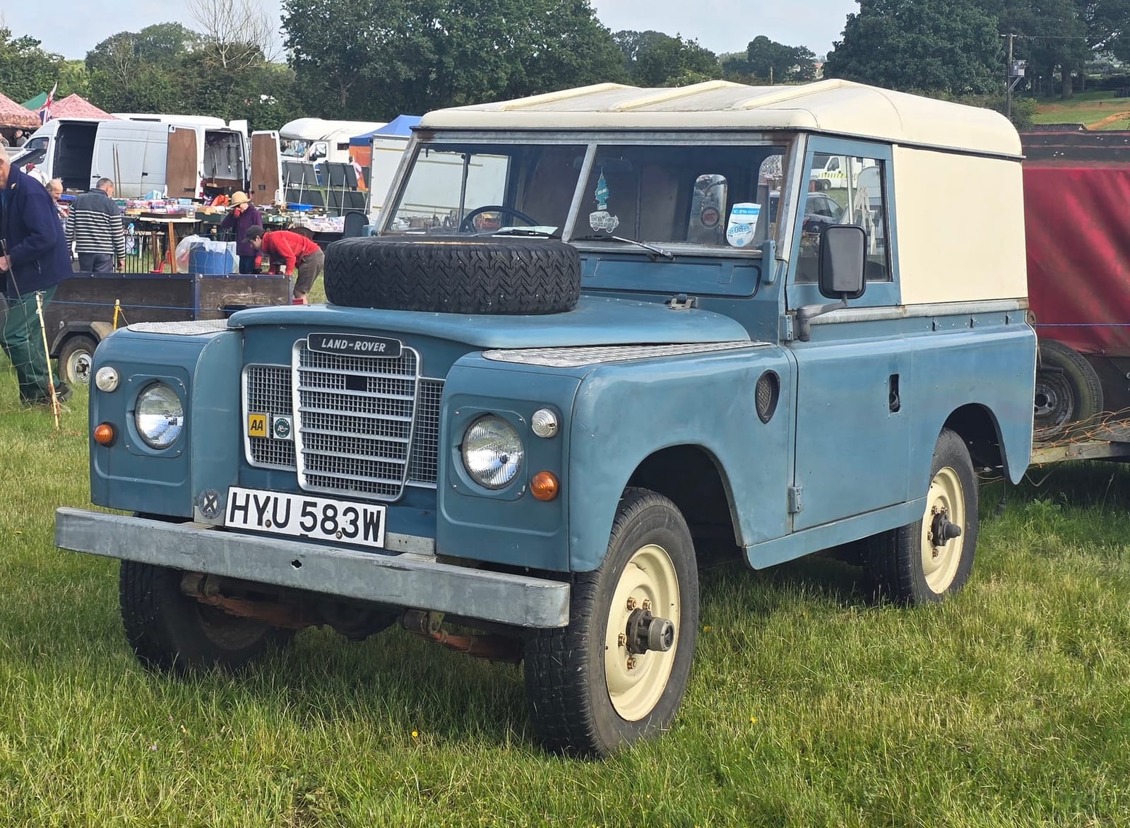 A blue 1981 Land Rover Series III 88 hardtop with a UK registration on a show field