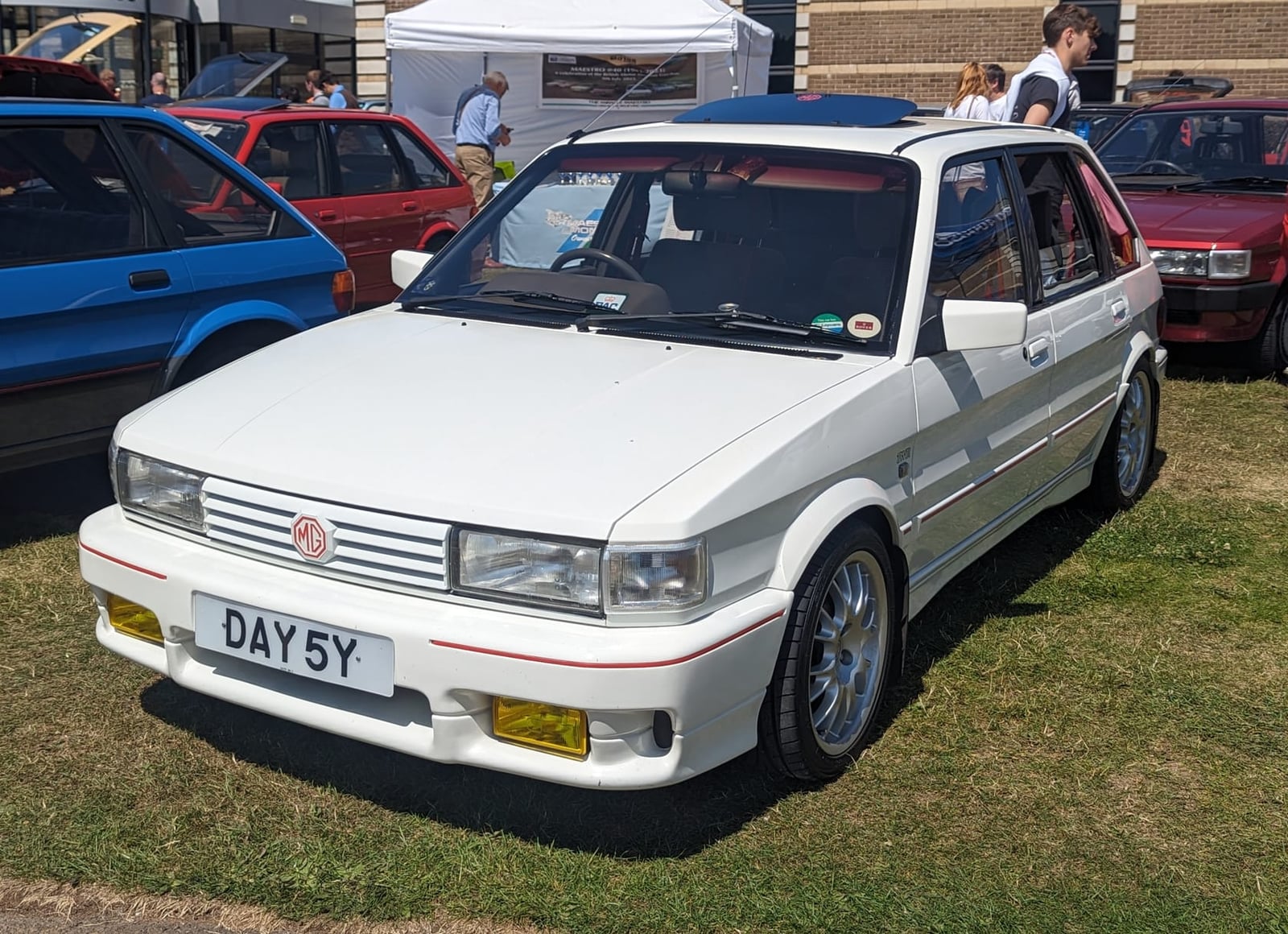 A red MG Maestro with its bonnet raised showing the 2.0-litre O-series engine