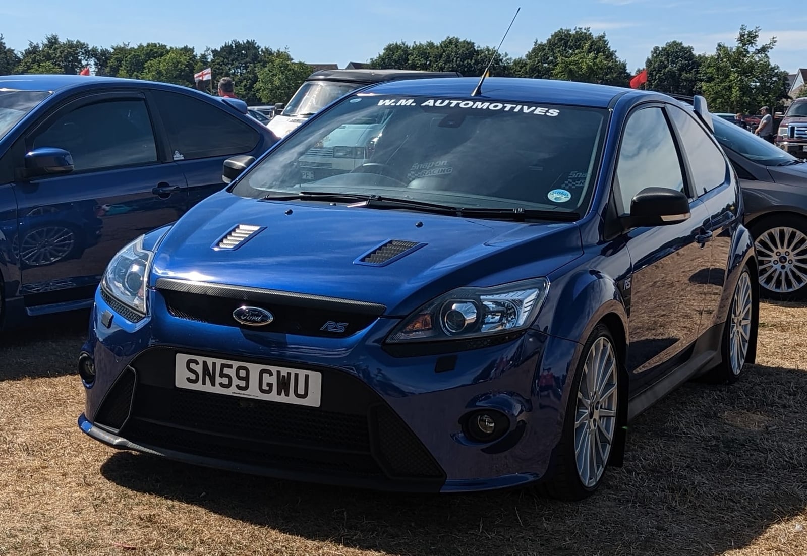 A dark blue 2009 Ford Focus RS Mk2 with a UK registration on a show field