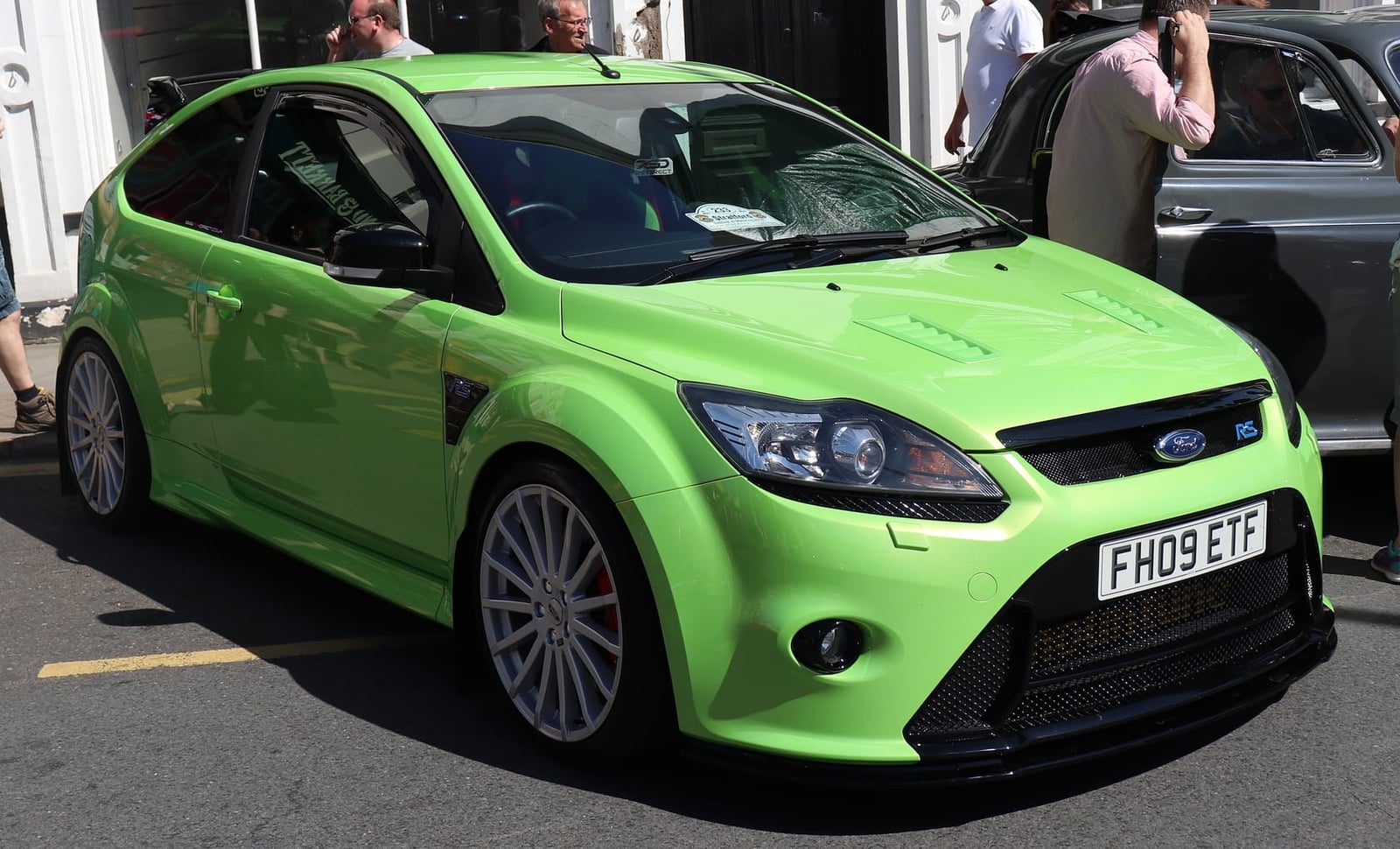 An Ultimate Green 2009 Ford Focus RS Mk2 with a UK registration parked in a street at a show