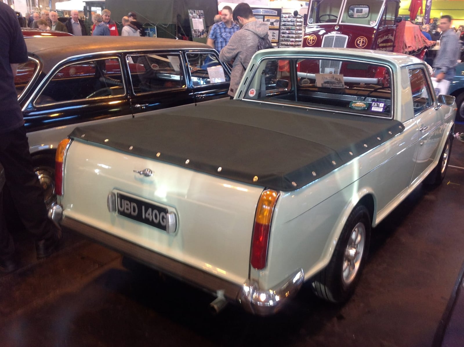 A silver Austin 1800 utility with a tonneau-covered load bed displayed at an indoor show