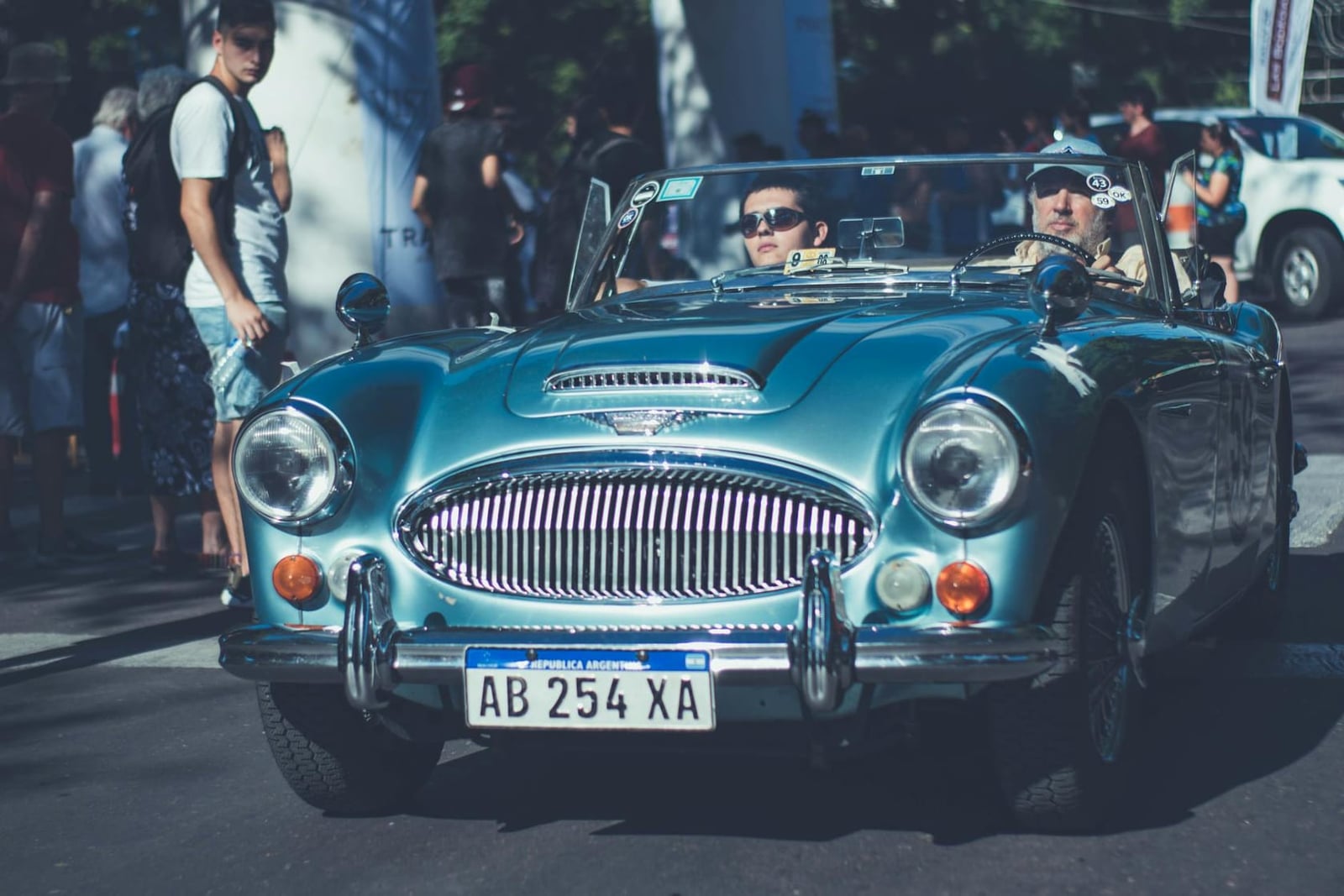 A light blue Austin-Healey 3000 with two crew on a classic-car rally