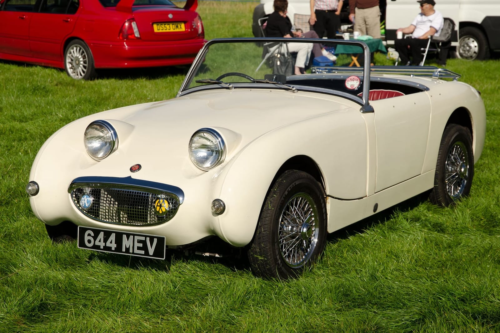 A cream 1958 Austin-Healey Sprite Mk I with wire wheels and a UK registration on a show field