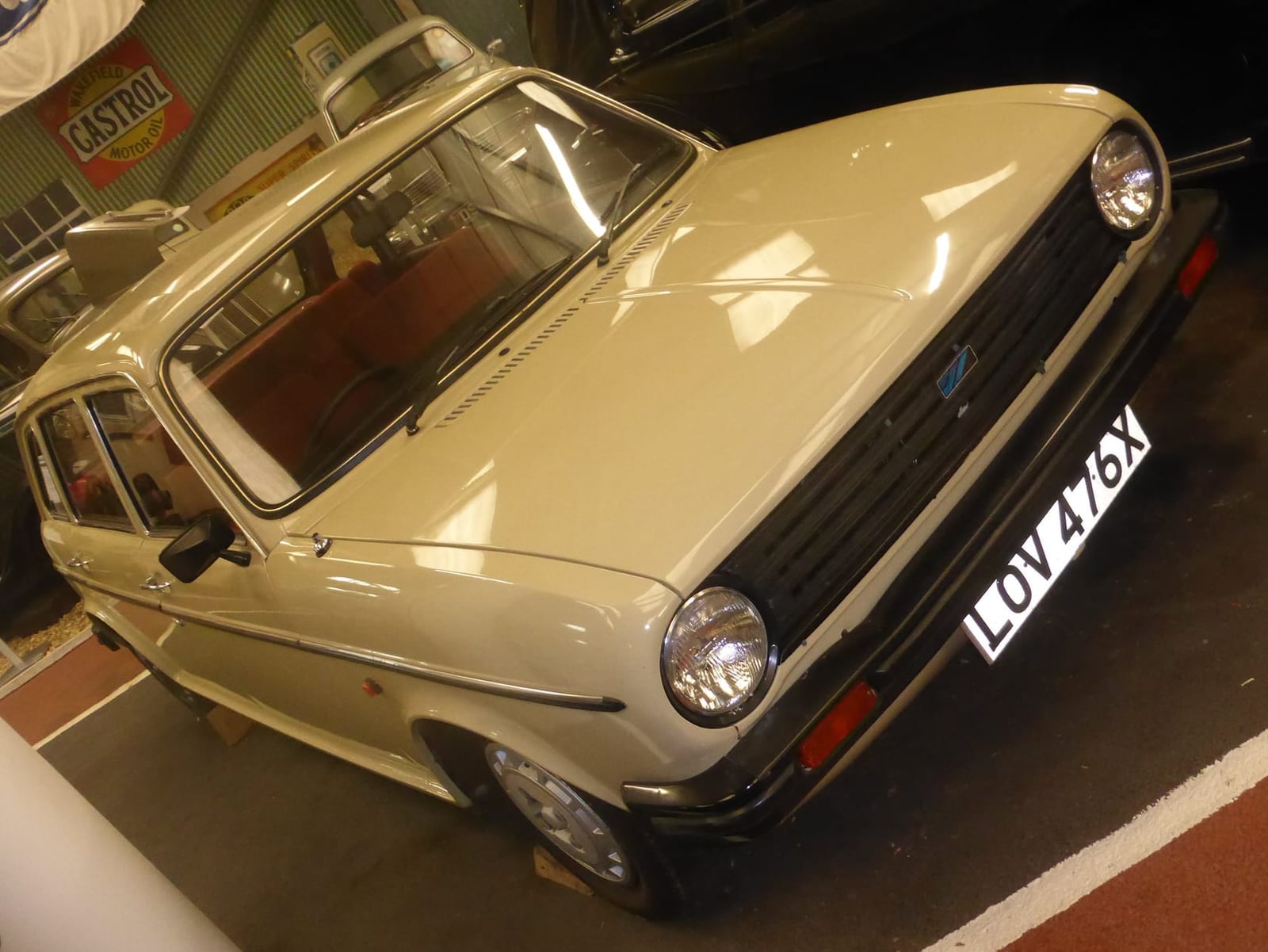 A beige 1981 Austin Maxi 1750 on indoor display, front three-quarter view, UK registration LOV 476X
