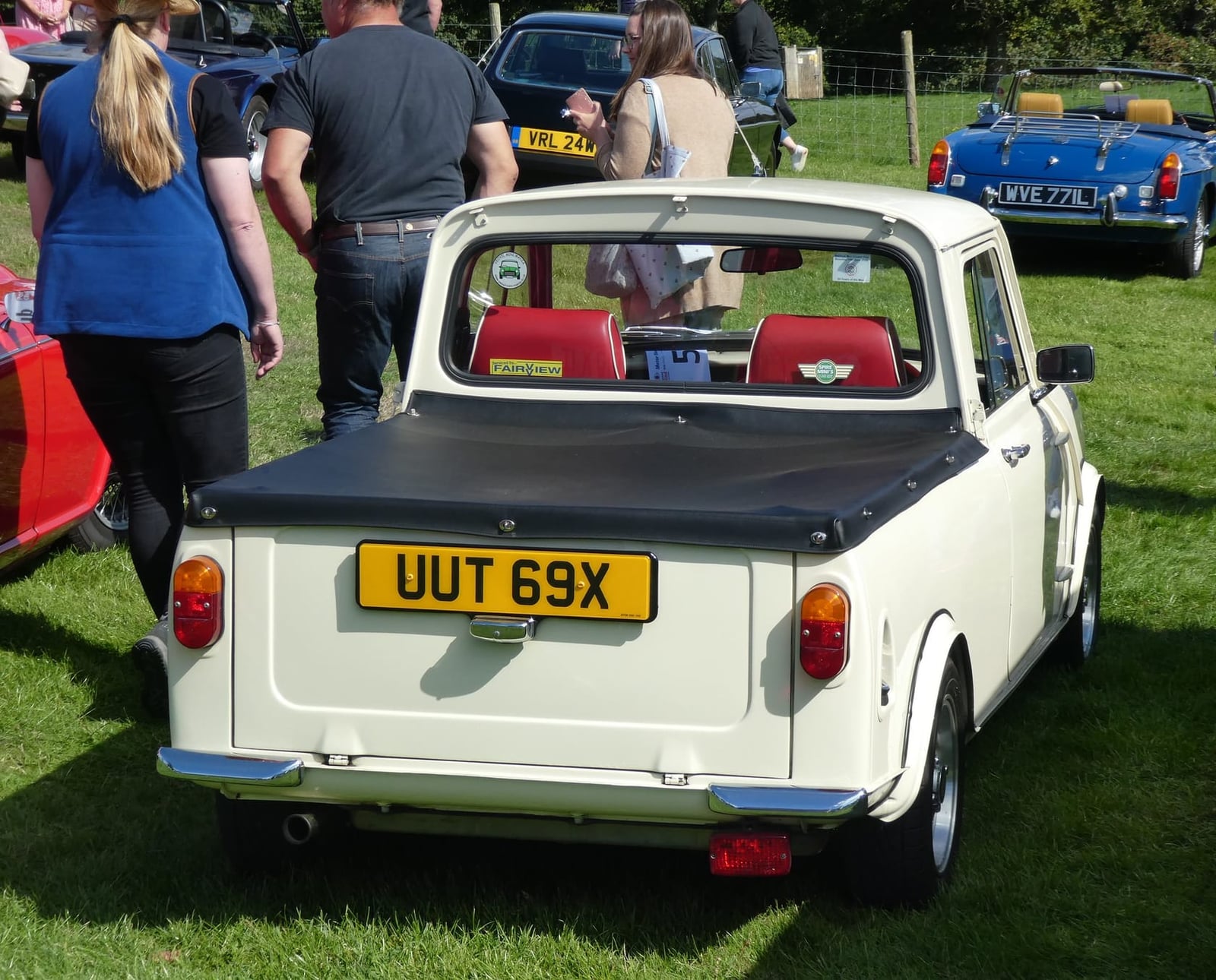 A white Mini Pick-up at a show, rear three-quarter view showing the load bed