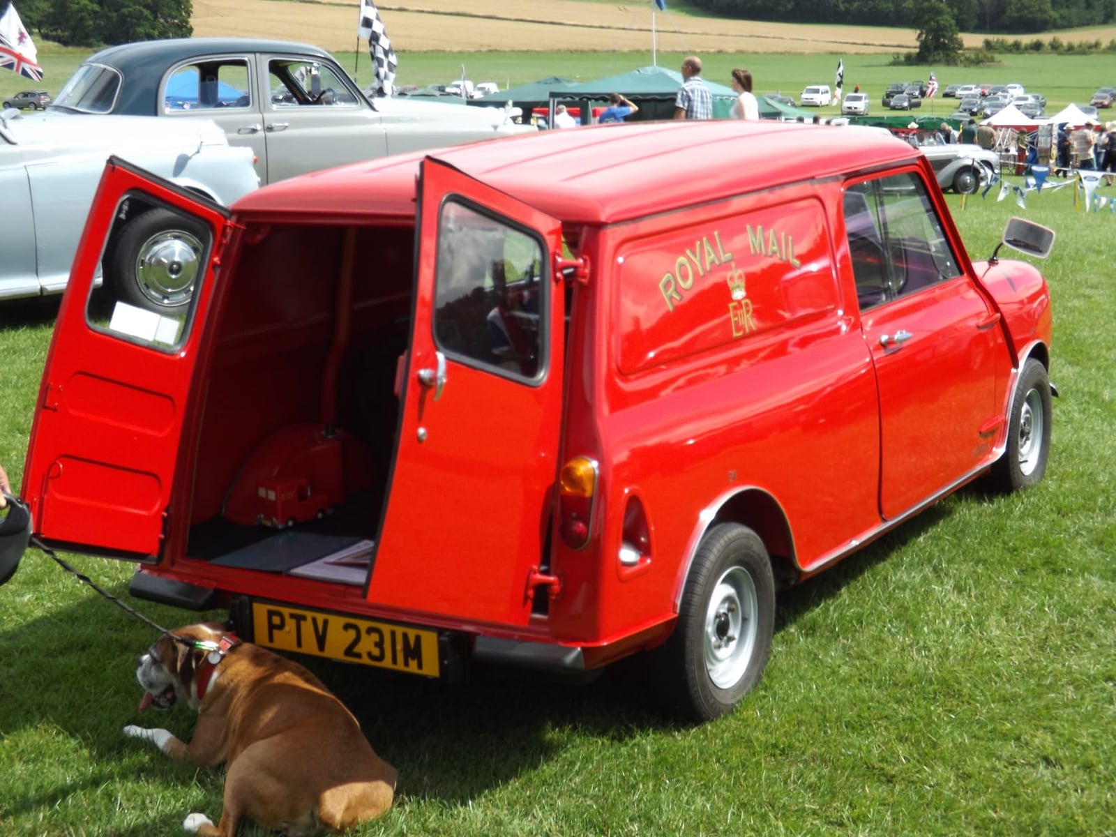A red Mini Van in Royal Mail livery with its rear doors open