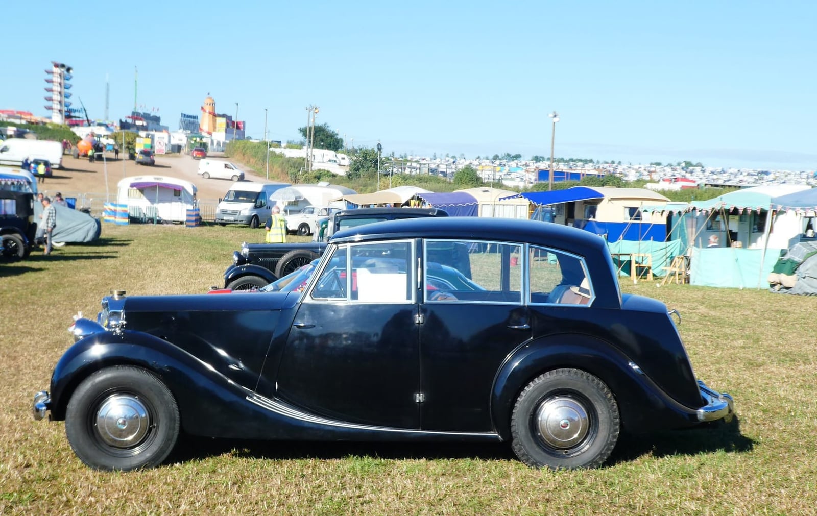 A dark blue Triumph Renown in side profile on grass at a classic car rally