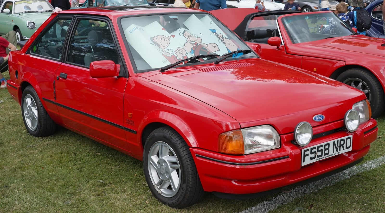 A red Ford Escort XR3i hatchback at a show, front three-quarter view