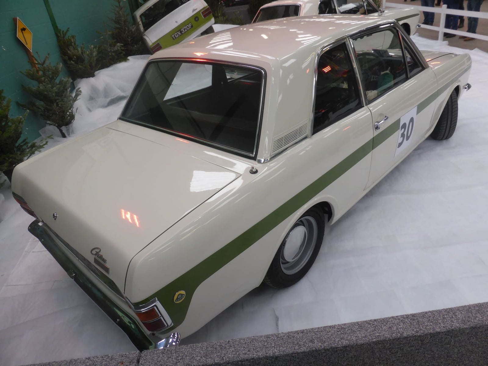 A white Lotus Cortina Mk2 with the green side flash on museum display, rear three-quarter view, race number 30
