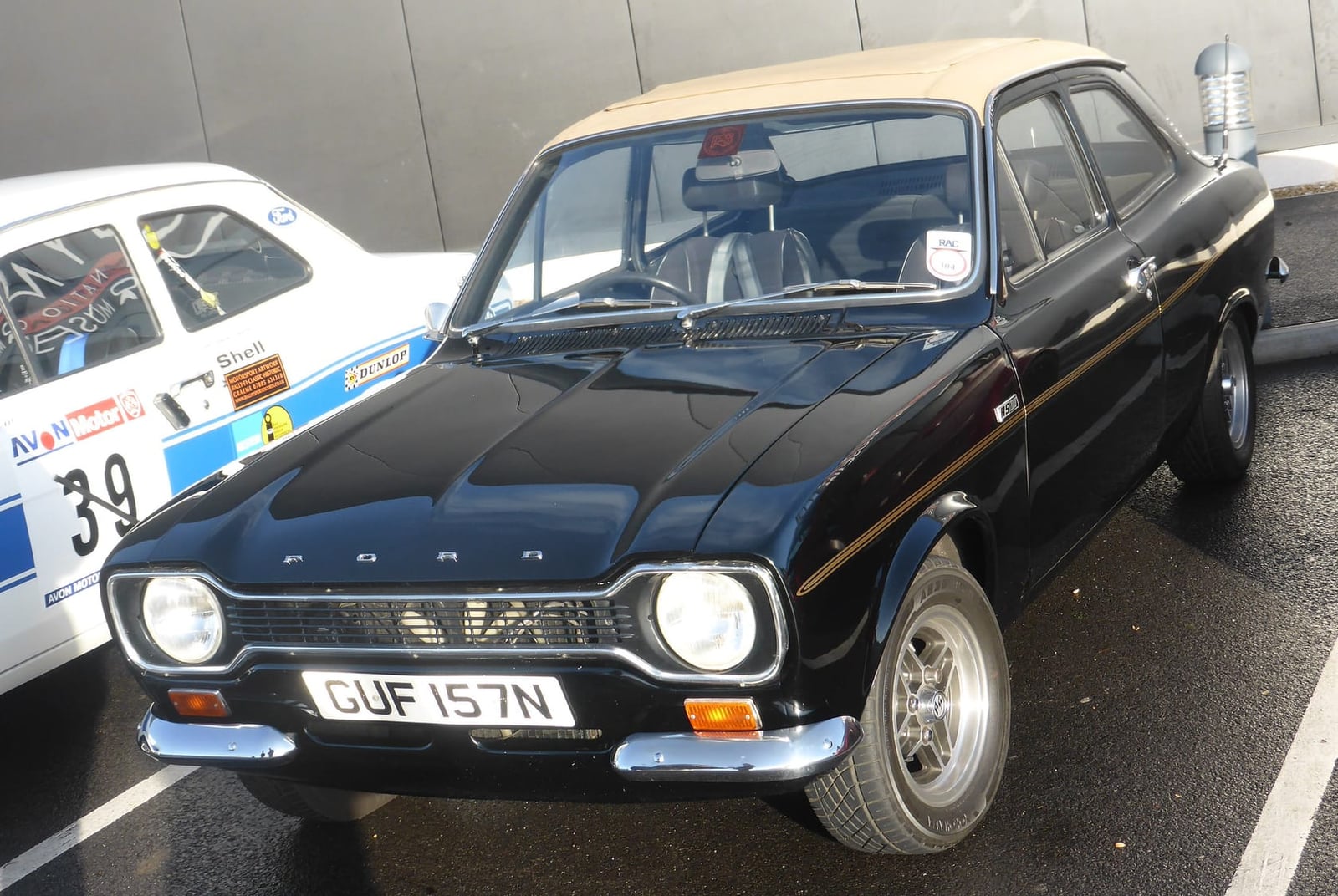 A black Ford Escort Mk1 RS2000 at a classic car meet, front three-quarter view, UK registration GUF 157N