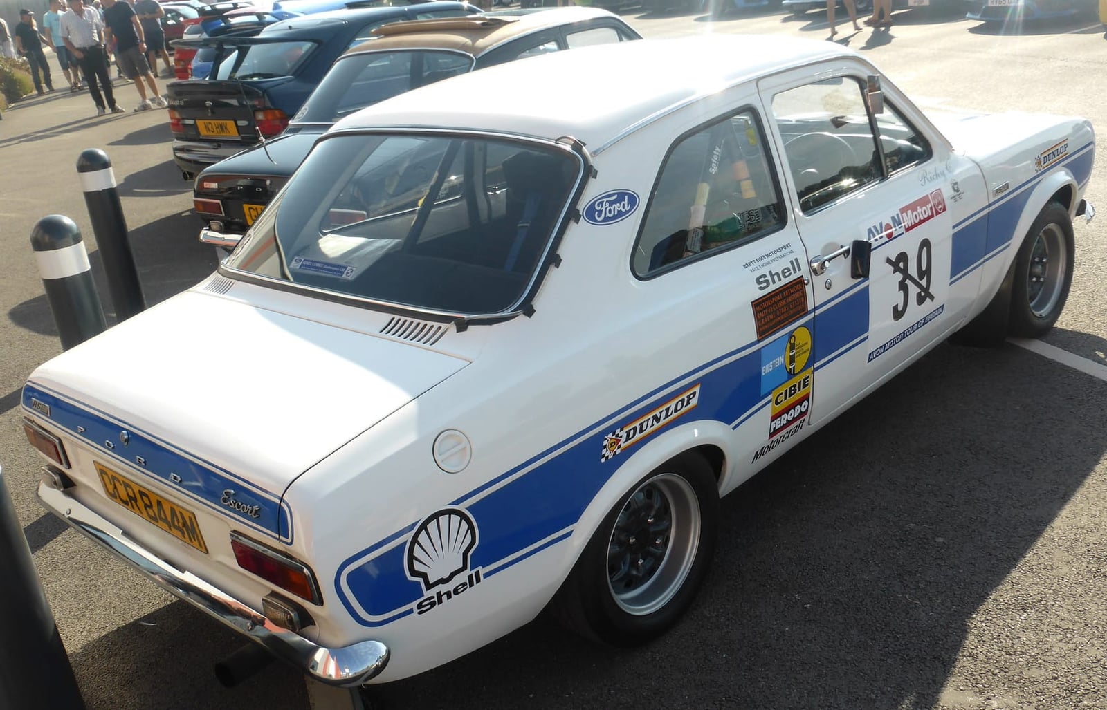 A white Mk1 Ford Escort RS2000 in period rally livery, rear three-quarter view