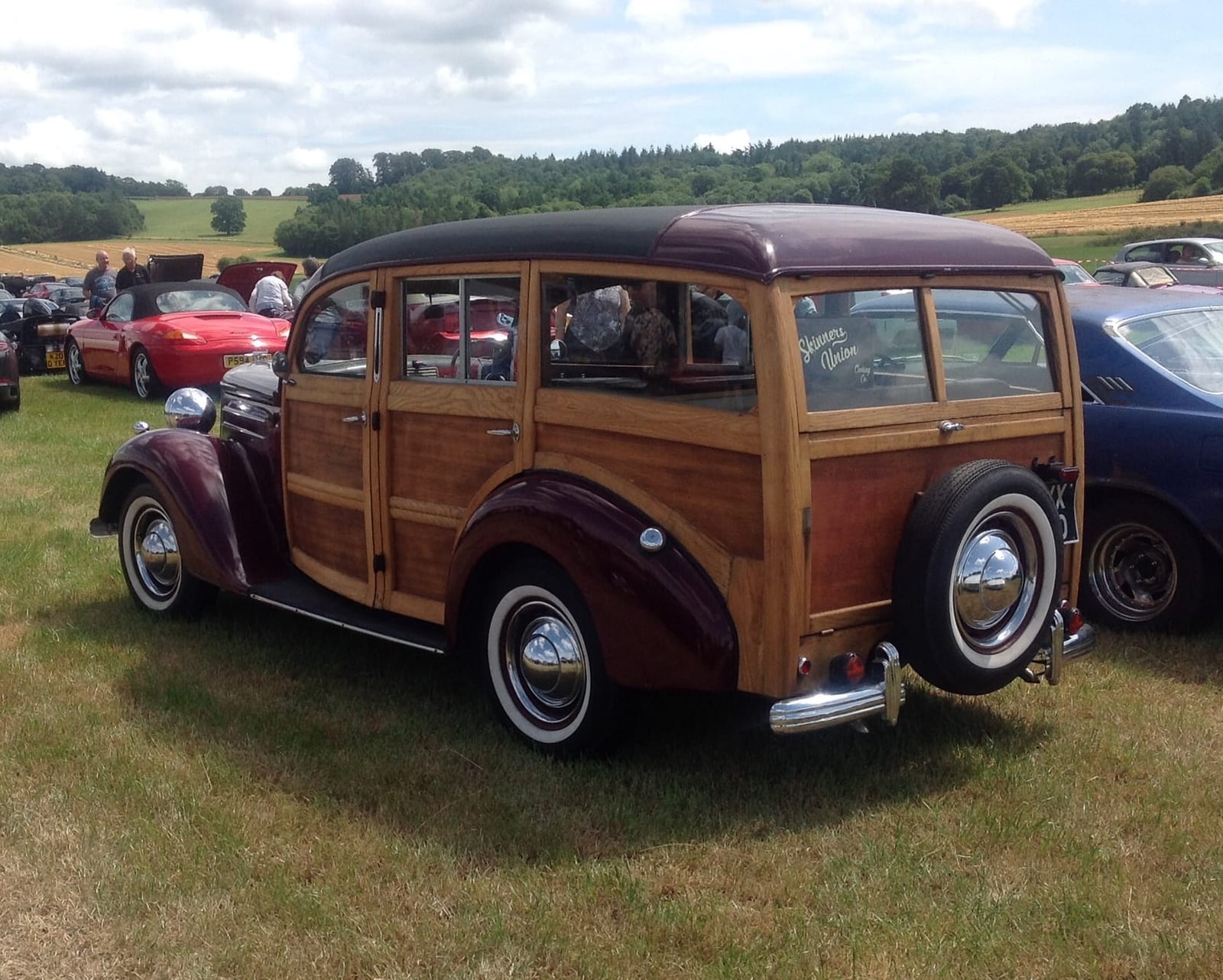 A 1950 Ford V8 Pilot woodie estate with timber-framed rear bodywork on grass at a classic car rally