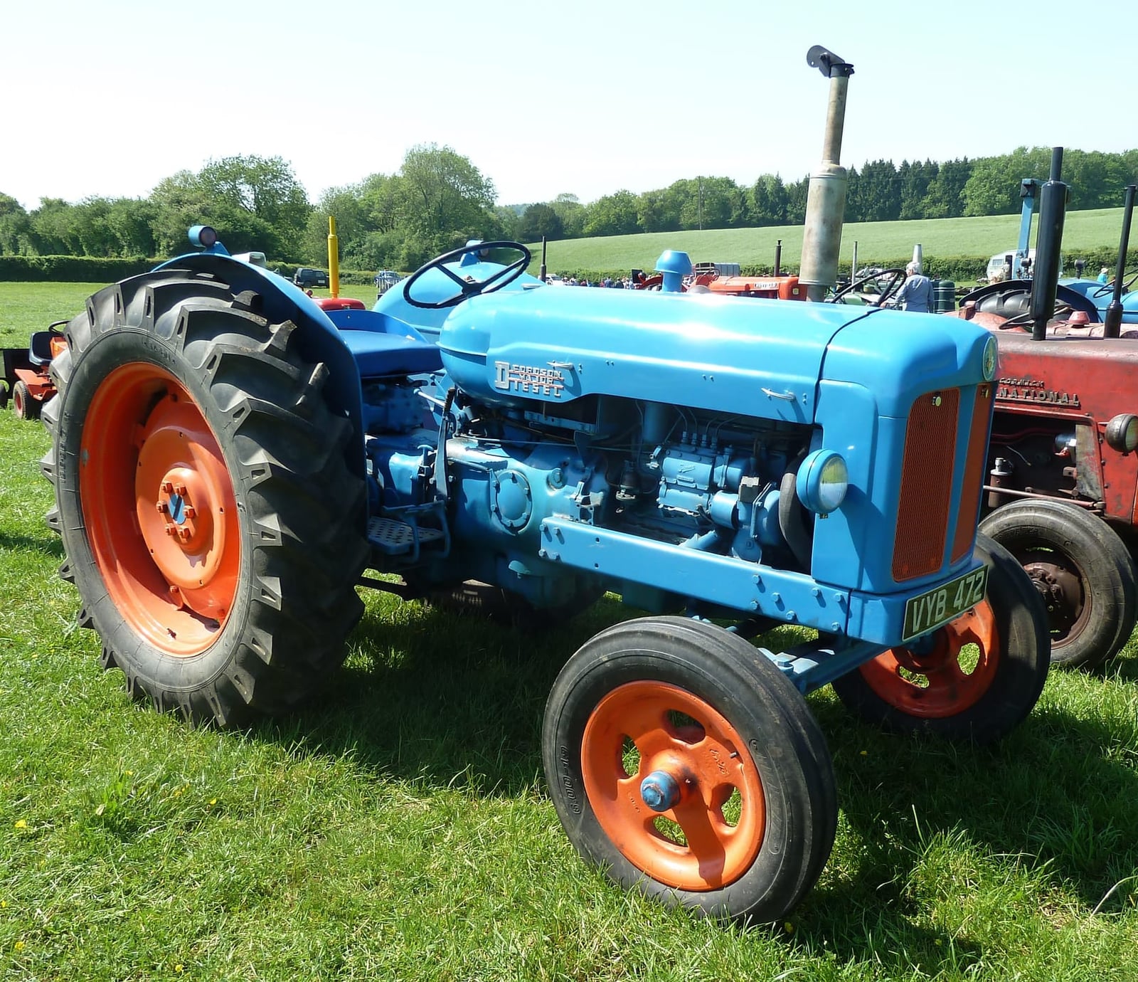 A blue Fordson Major with orange wheels at a vintage rally, side view