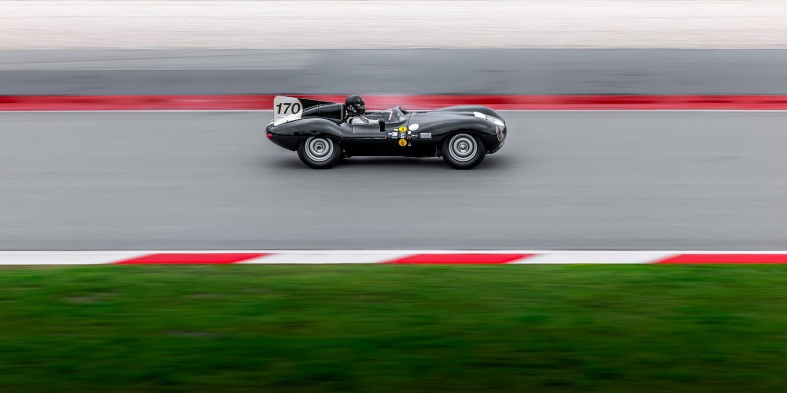 A Jaguar D-Type racing on a circuit