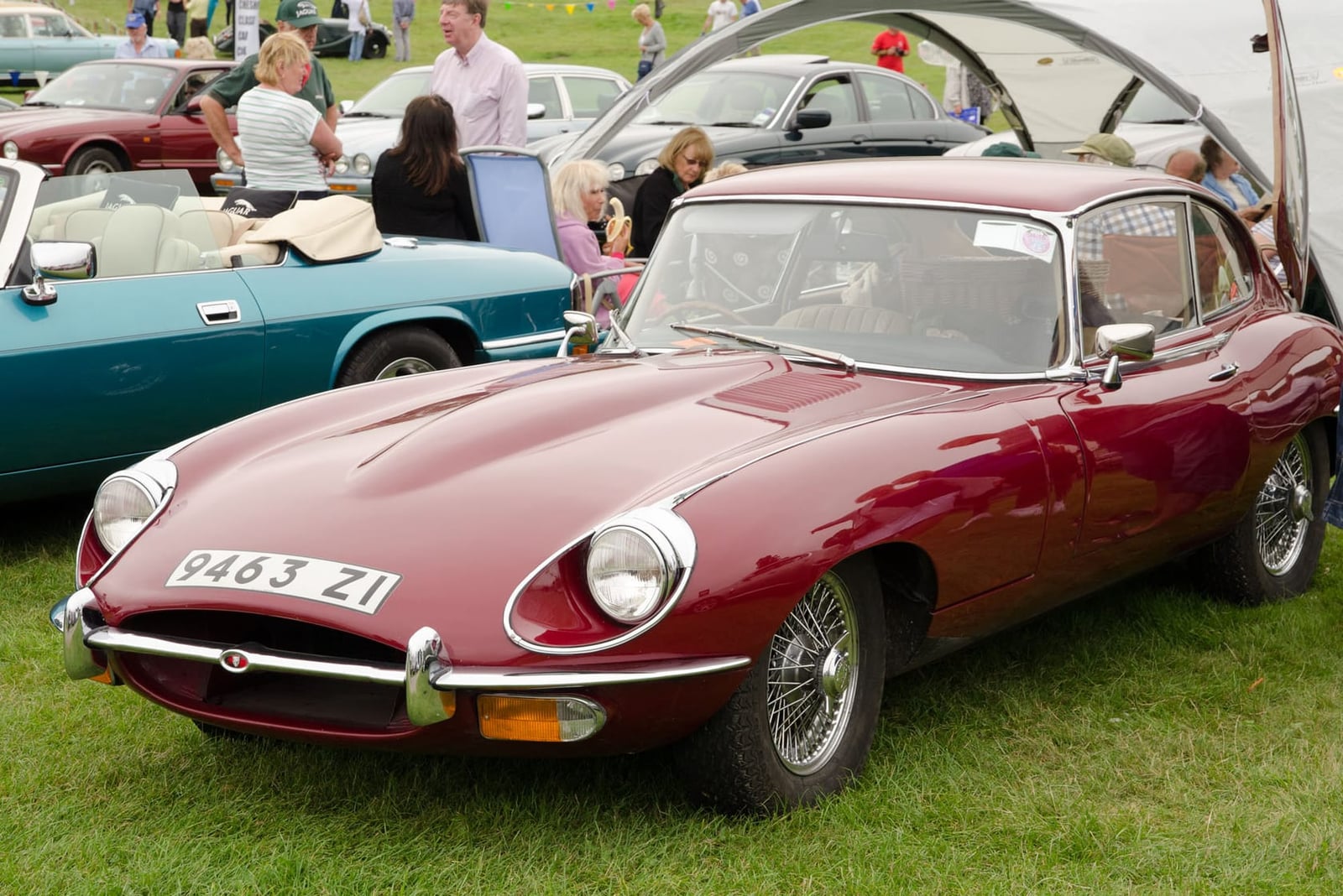 A maroon Jaguar E-Type Series 2 fixed-head coupe with registration 9463 ZI at a classic car show