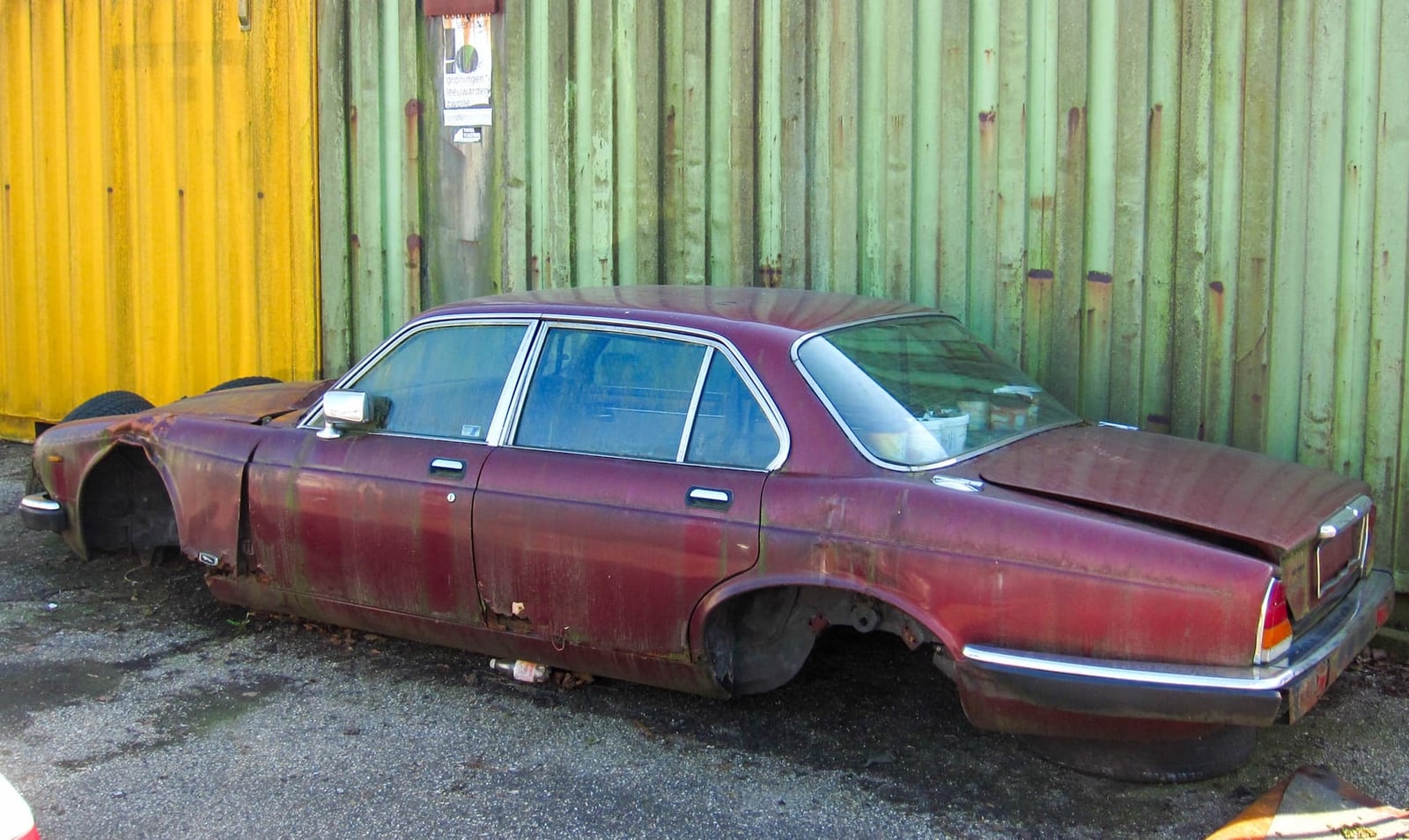 A dark green Jaguar XJ Series 3 with a UK registration parked on grass at a show