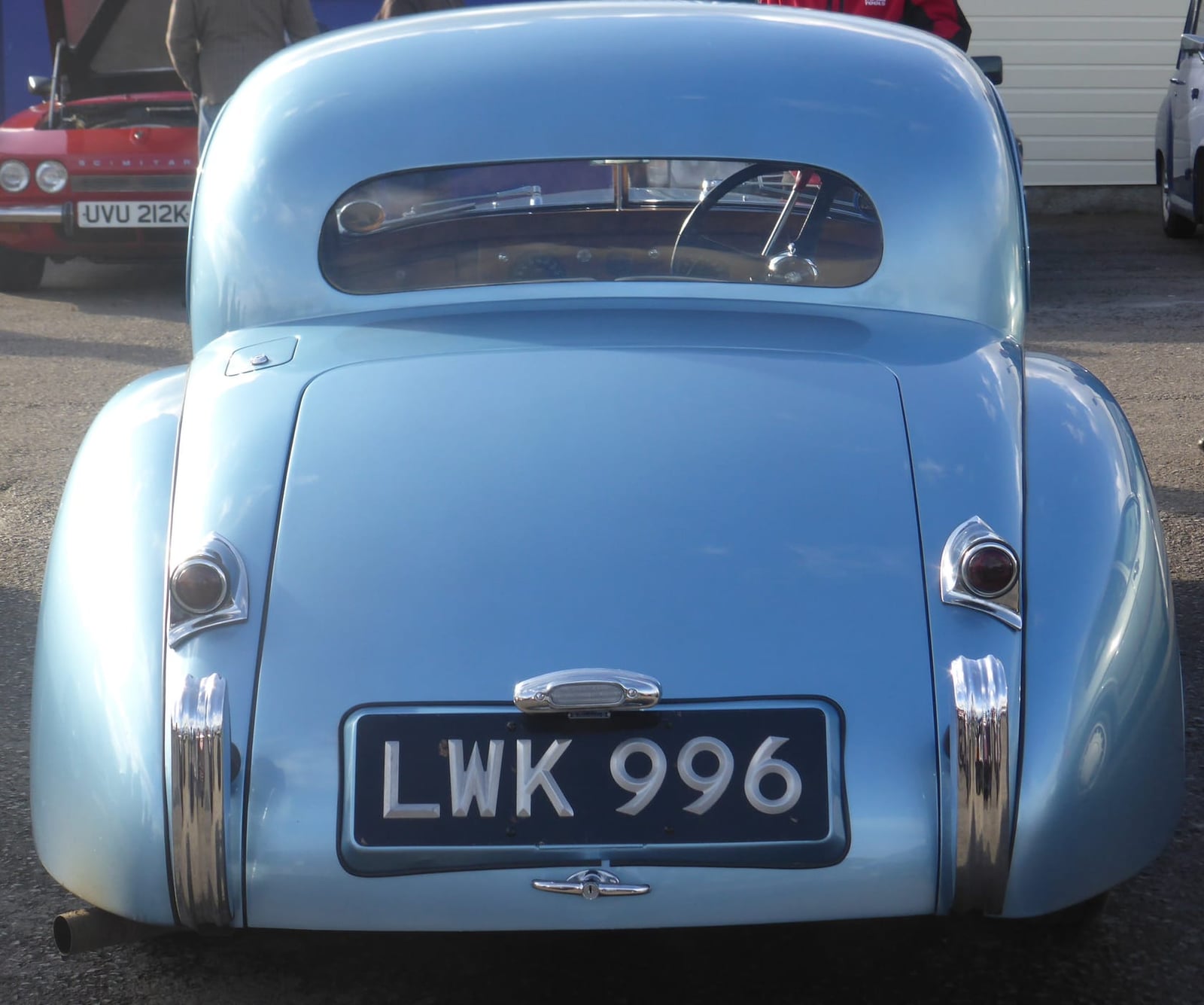 The rear of a pale blue 1952 Jaguar XK120 fixed-head coupé with a UK registration, parked at a show