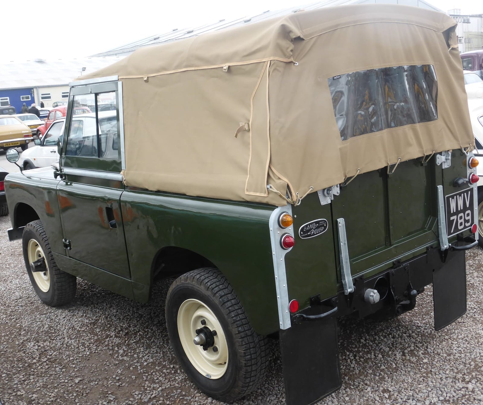 The rear of a dark green 1960 Land Rover 88 Series II with a canvas tilt and a UK registration at a show