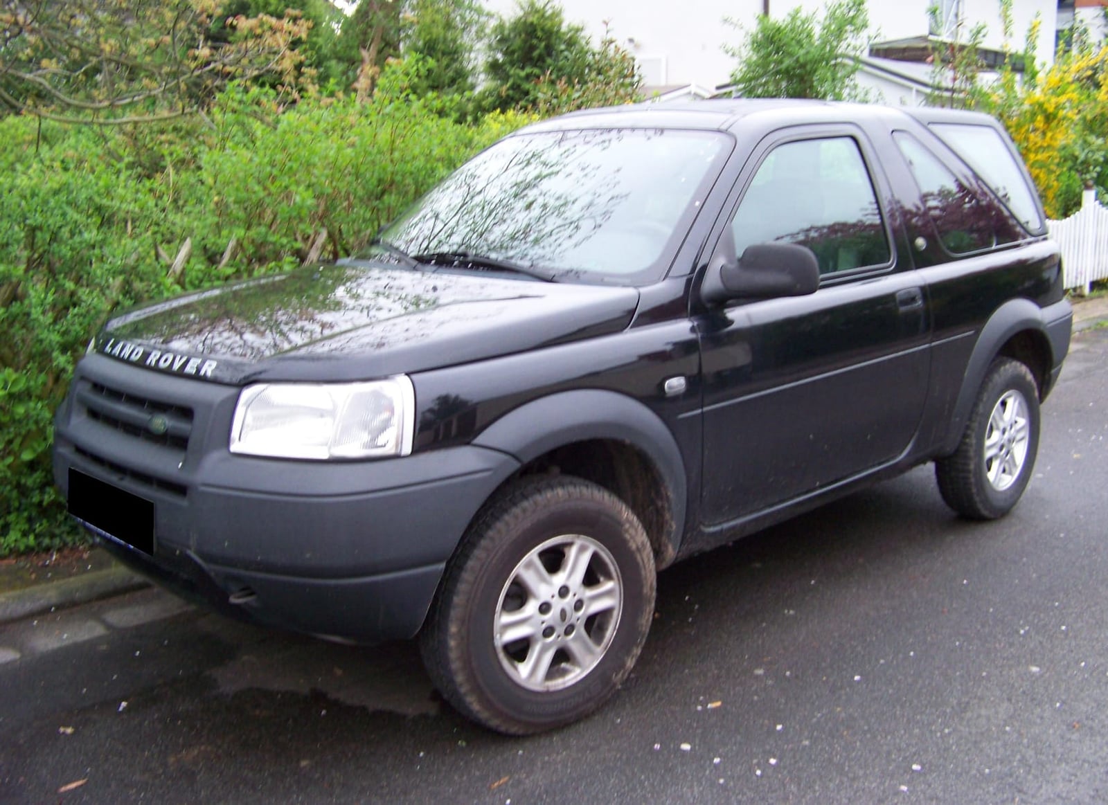 A black pre-facelift Land Rover Freelander three-door Hardback parked beside a hedge