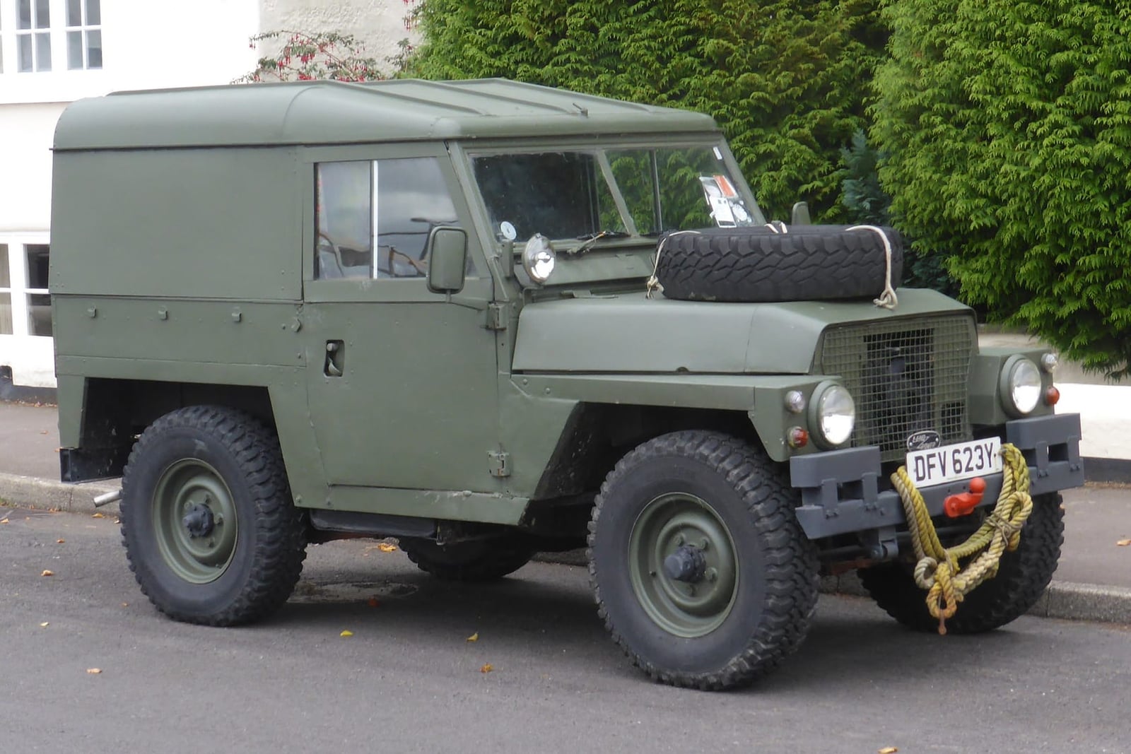 A green Land Rover Lightweight hardtop parked on a driveway, side view, UK registration DFT 623Y