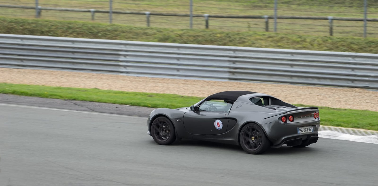 A grey Lotus Elise S2 on a circuit, seen from behind on a trackday