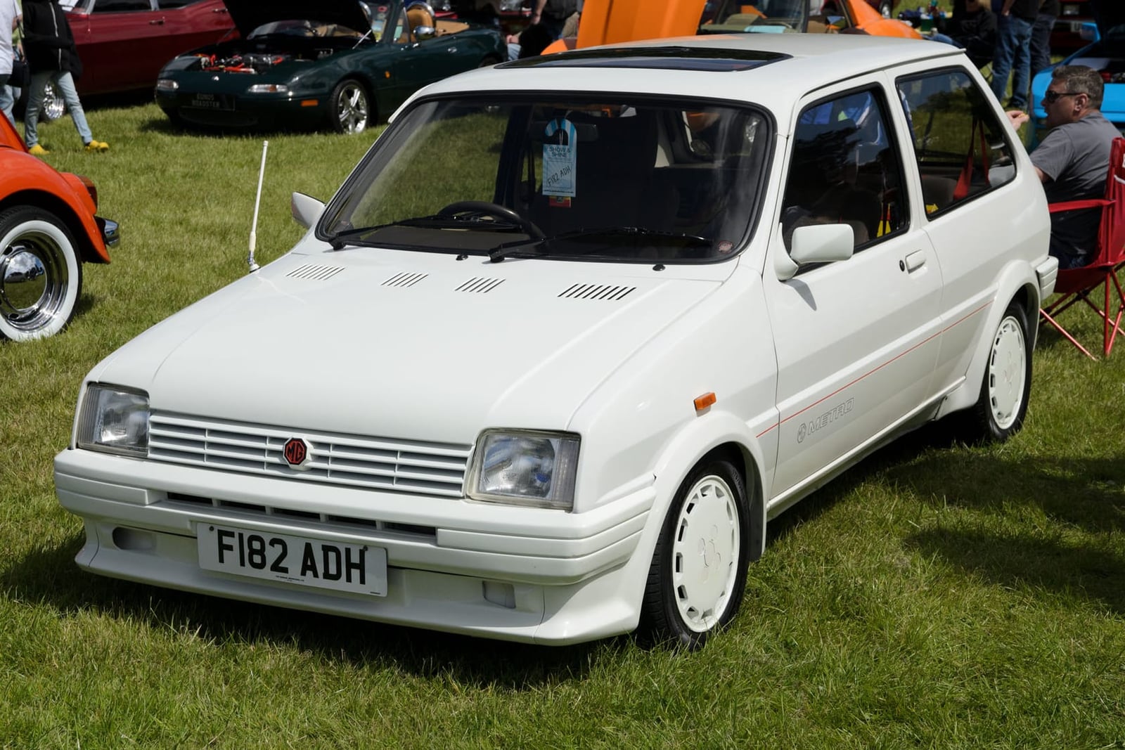 A white 1988 MG Metro at a classic car show, front three-quarter view, UK registration F182 ADH