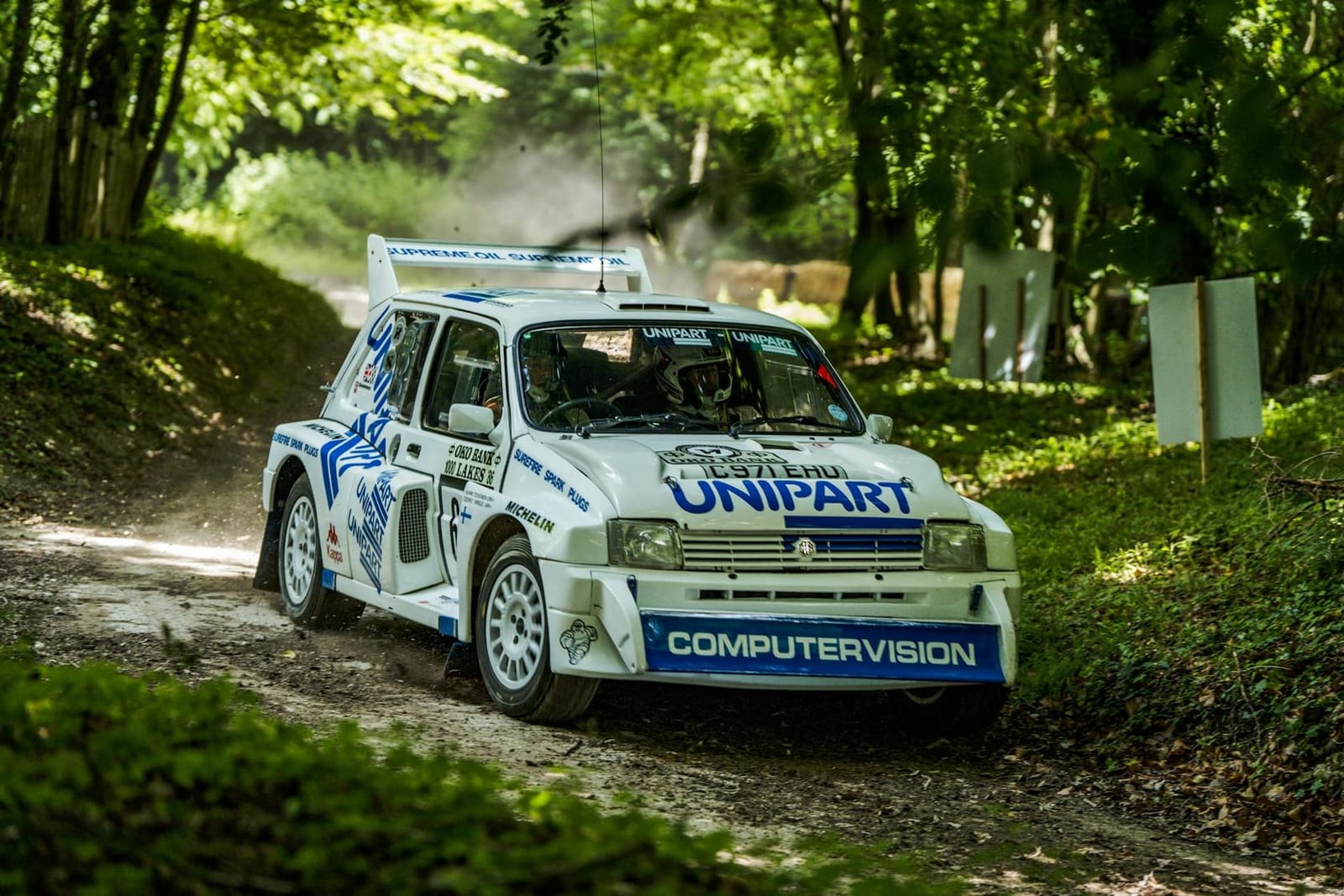 An MG Metro 6R4 rally car cornering on a forest stage