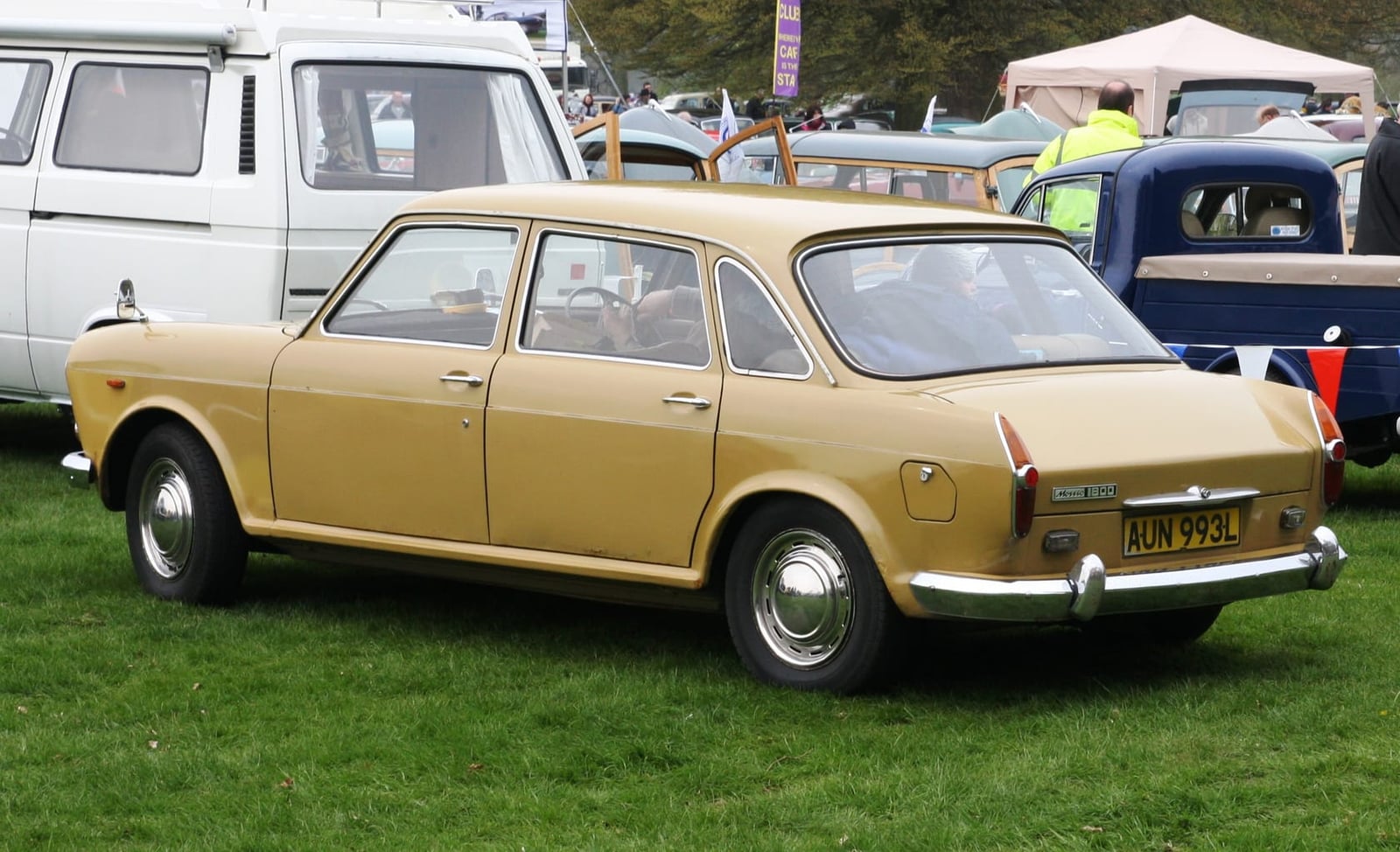 A gold 1972 Morris 1800 Mk II on grass at a classic vehicle show, rear three-quarter view, UK registration AUN 993L