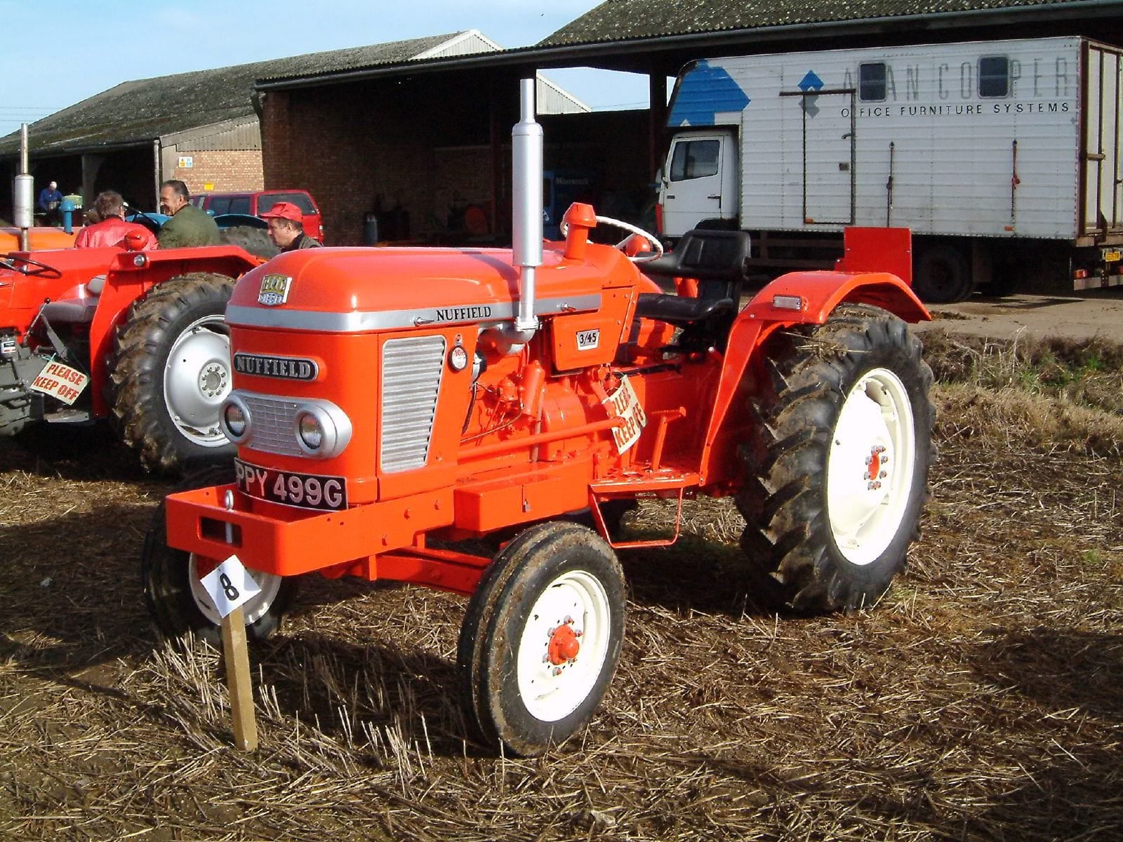 An orange Nuffield 3/45, registration PPY 499G, at a show