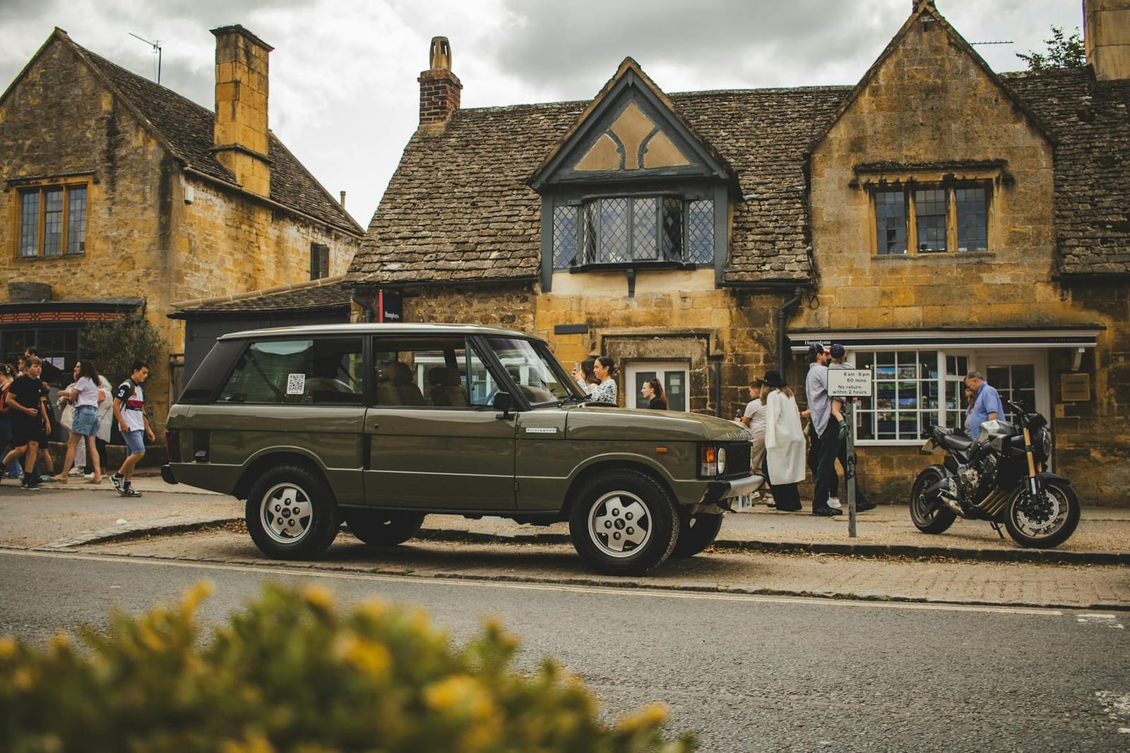 A Range Rover Classic parked on a Cotswold stone high street