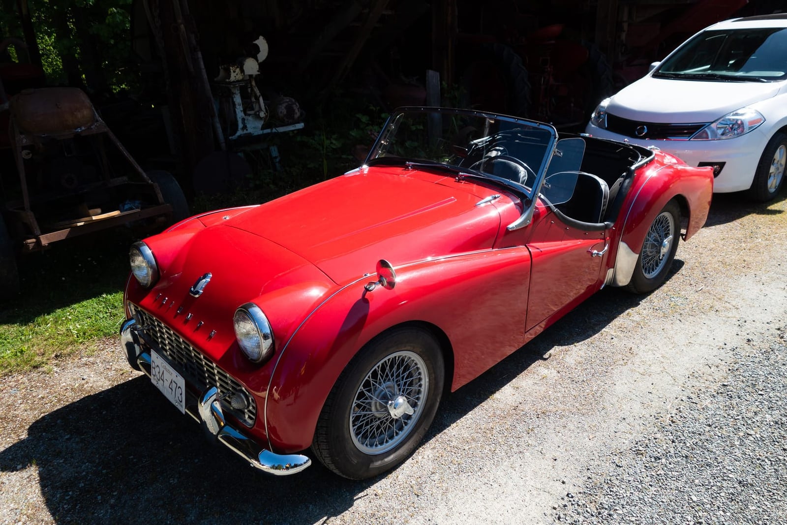 A red Triumph TR3 roadster with the hood down, front three-quarter view
