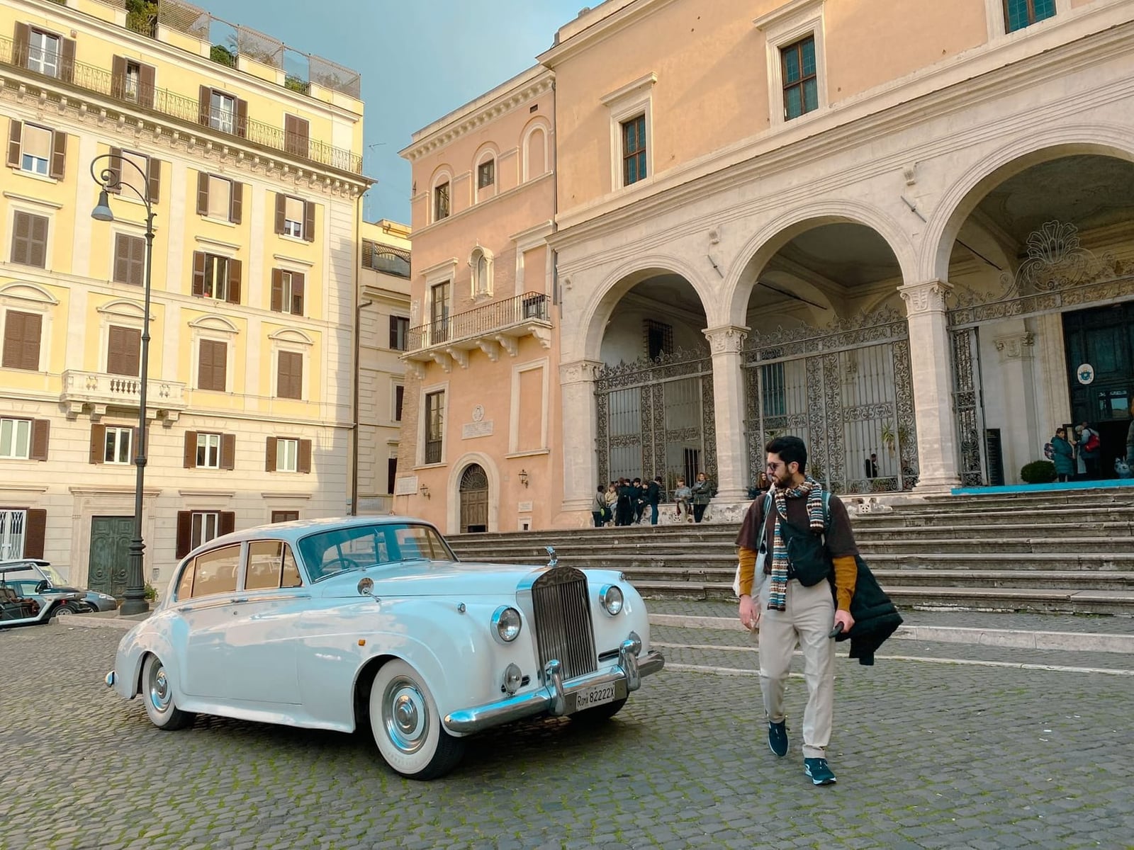 A pale blue and white Rolls-Royce Silver Cloud in an Italian city square