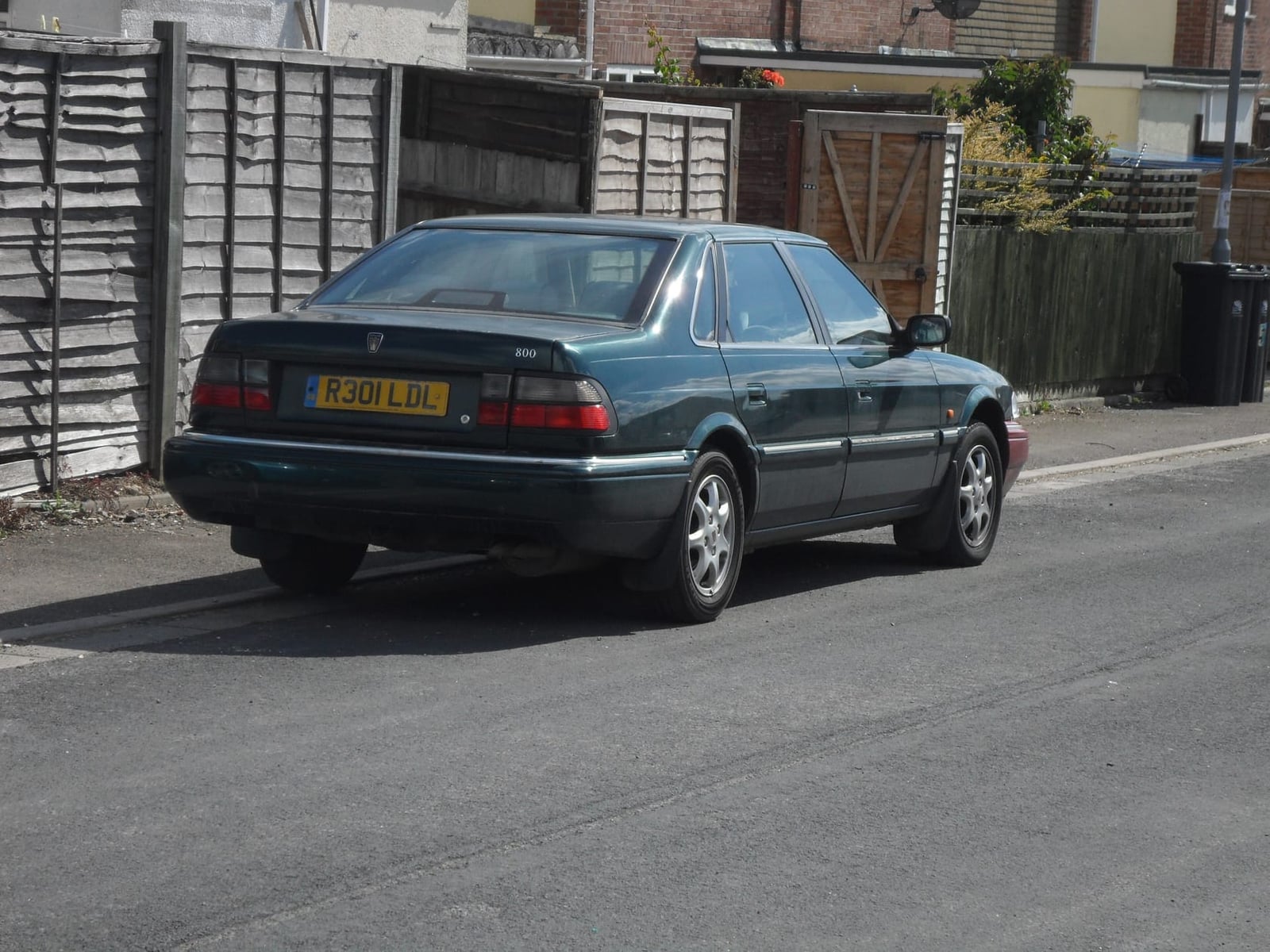The rear of a dark green 1998 Rover 800 2.5 diesel saloon with a UK registration parked in a residential street
