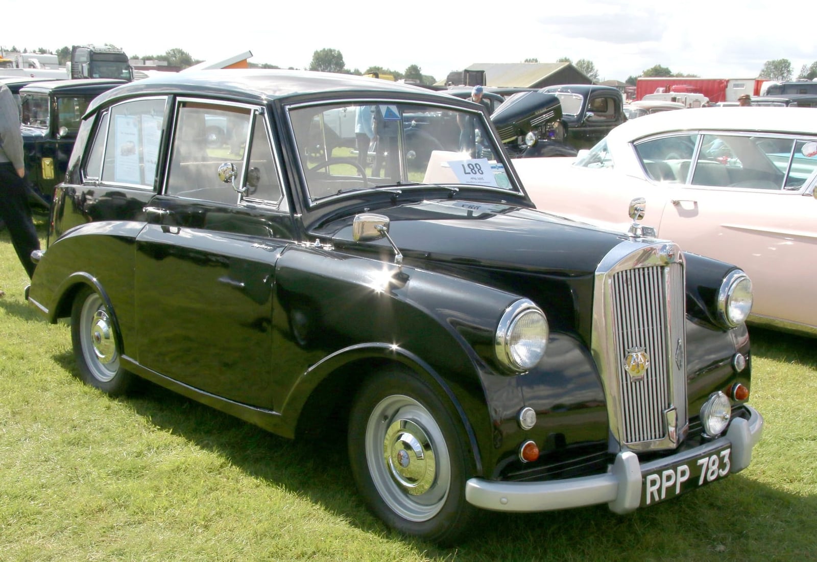 A dark green 1953 Triumph Mayflower on grass at a steam rally, front three-quarter view, UK registration RPP 783