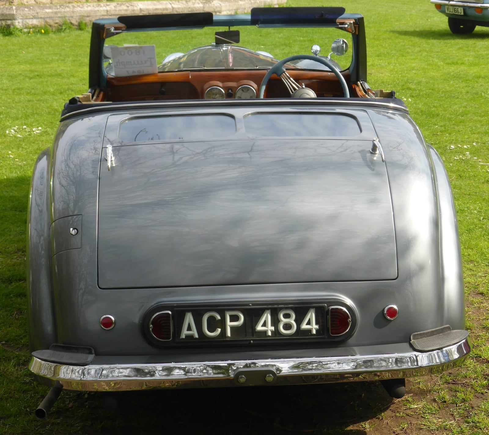 The rear of a grey Triumph 1800 Roadster showing the closed dickey-seat lid and rear-hinged bootlid, UK registration ACP 484
