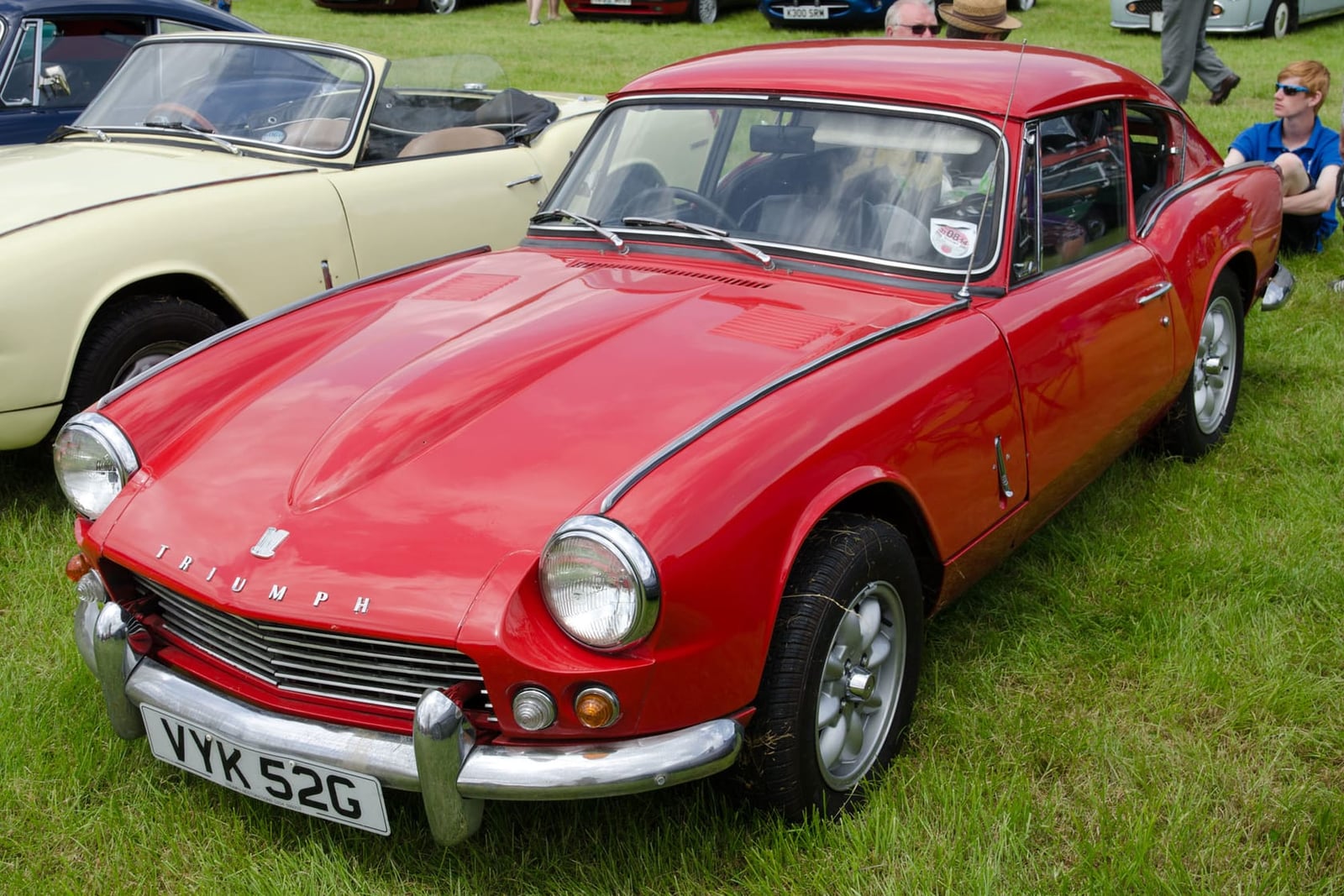 A red Triumph GT6 Mk1, front three-quarter view on grass